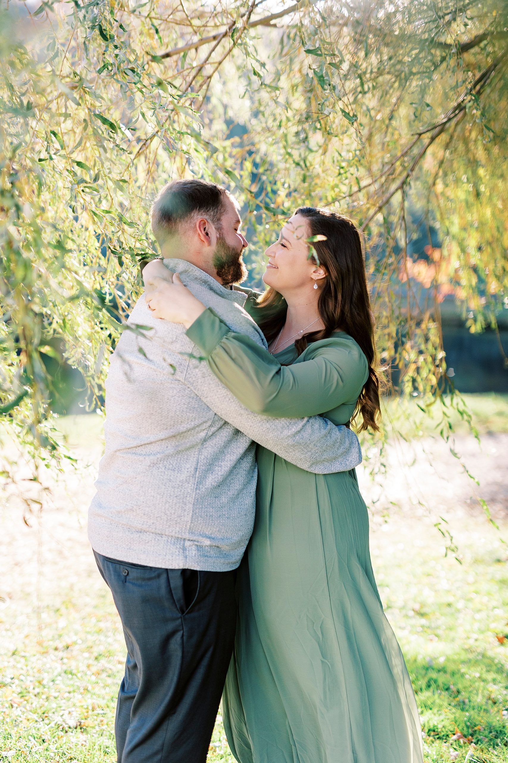 engaged couple hugs and dances under willow tree at Chetola Resort