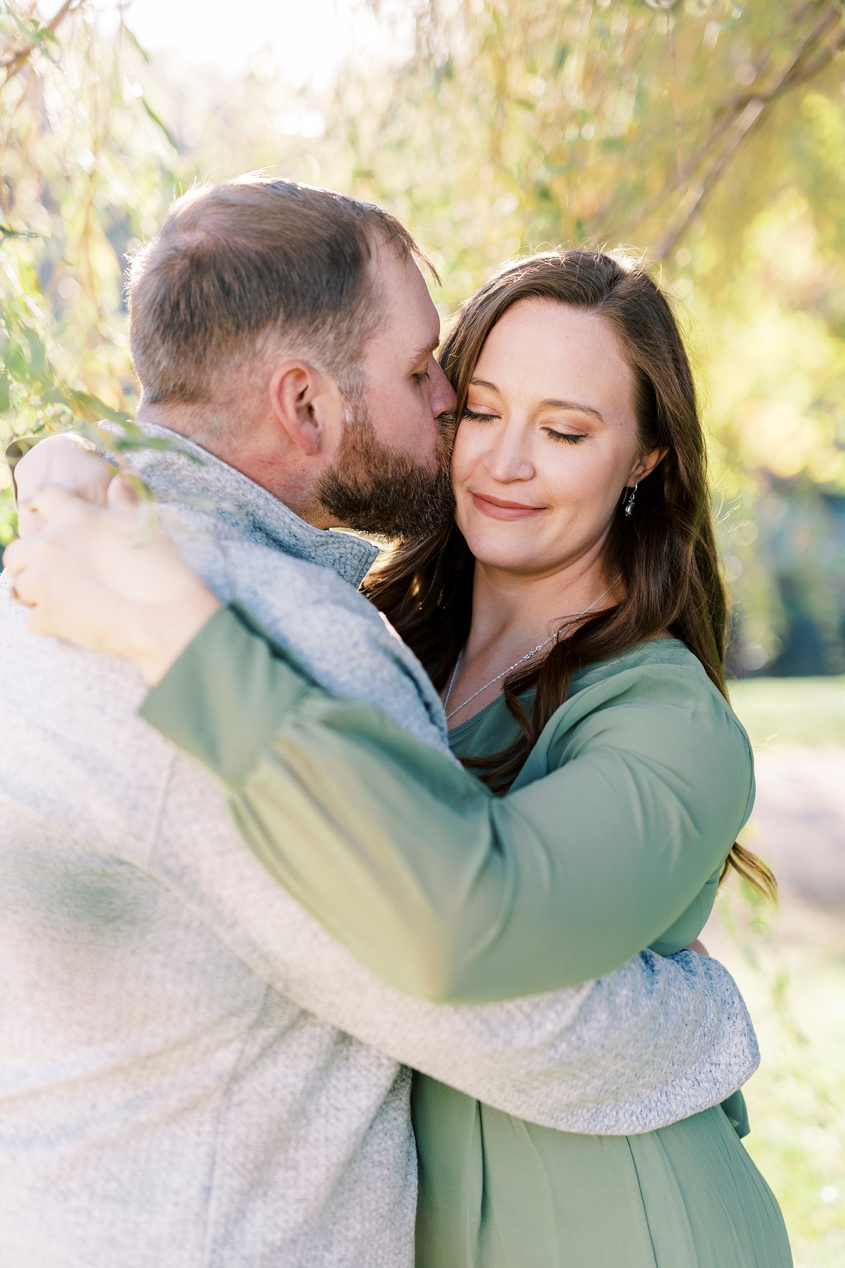 groom hugs bride to him kissing her cheek at Chetola Resort
