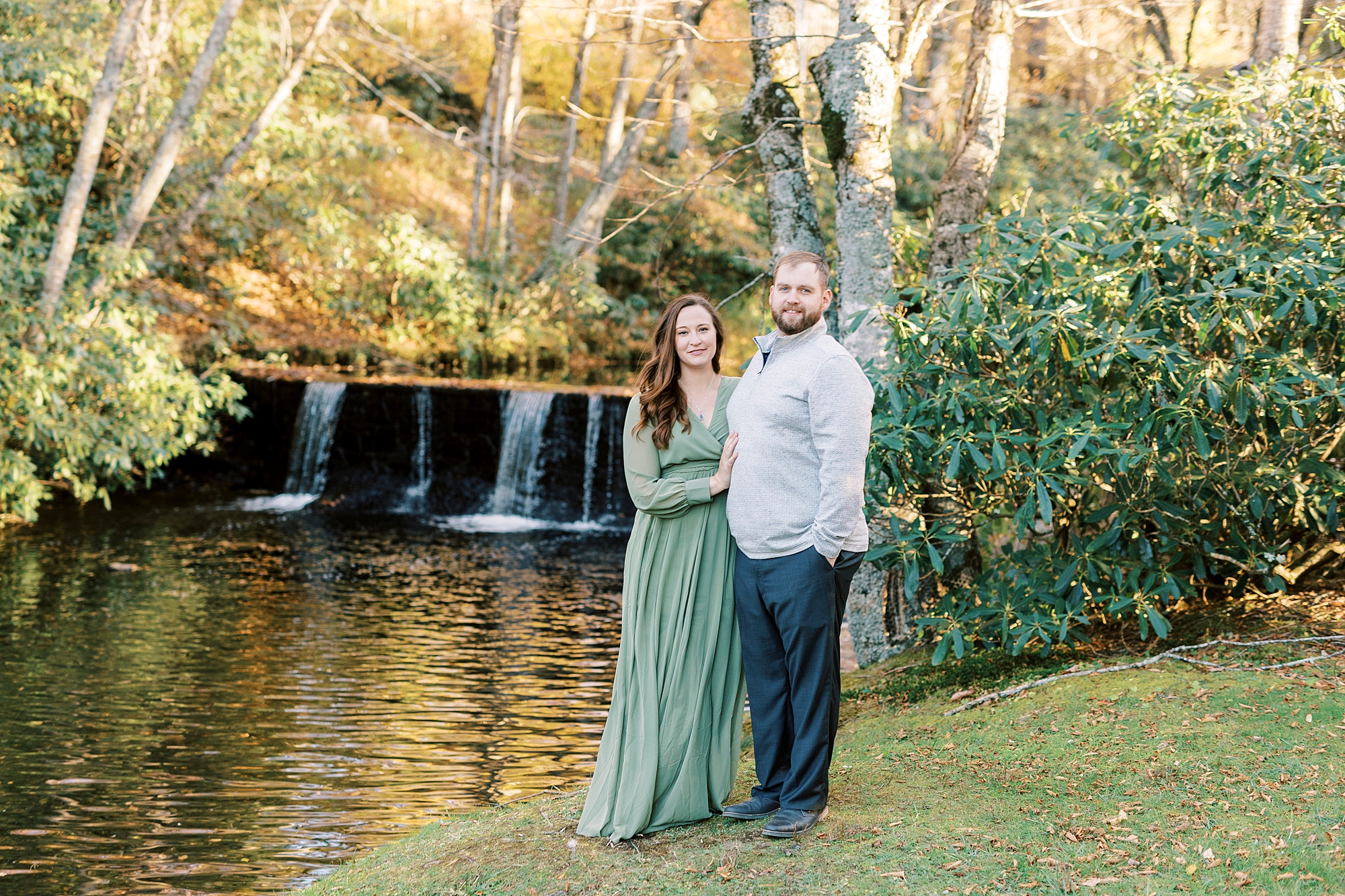 engaged couple poses along water fall at Chetola Resort