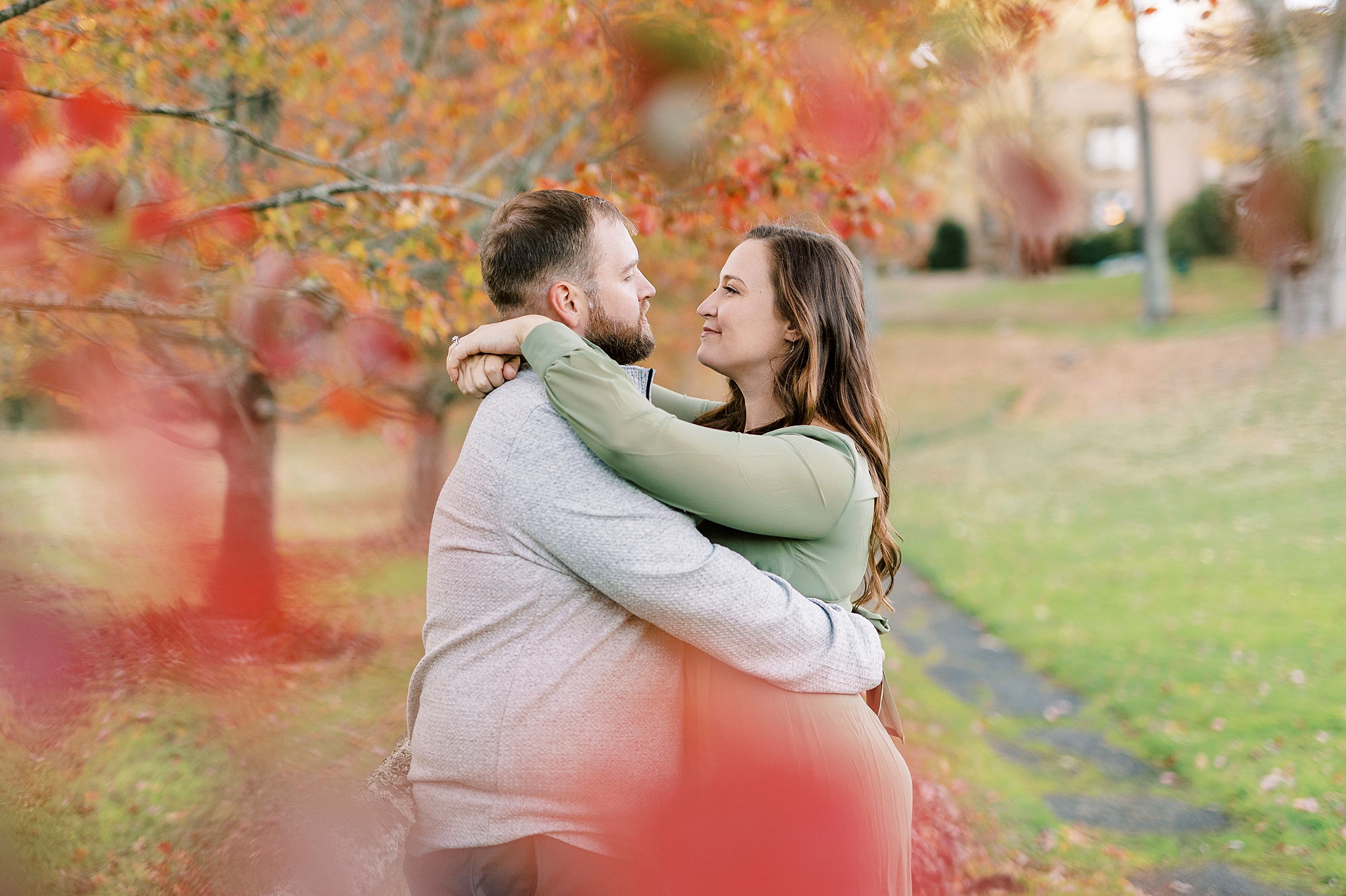bride and groom hug among red trees at Chetola Resort