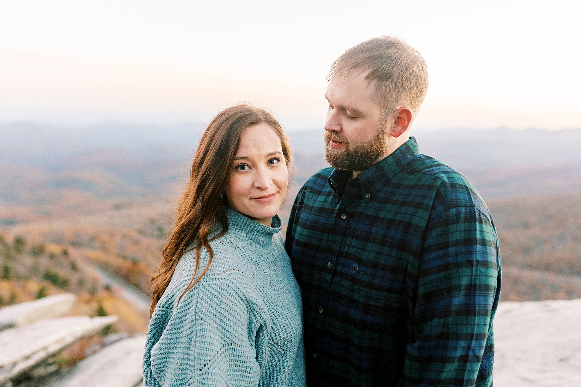 groom smiles at bride at top of Blue Ridge Parkway