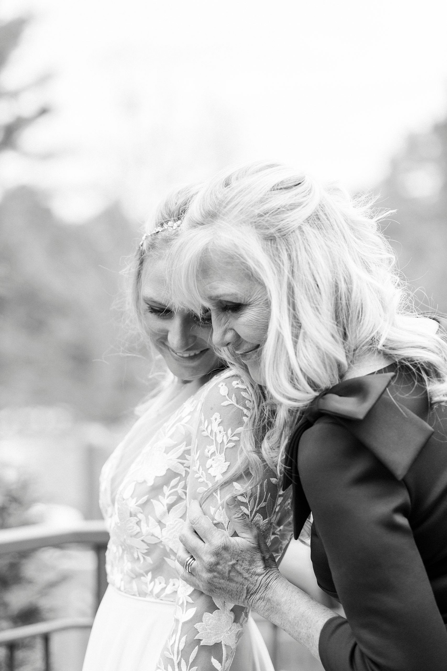 mother hugs bride after preparing for wedding day on balcony at Chetola Resort