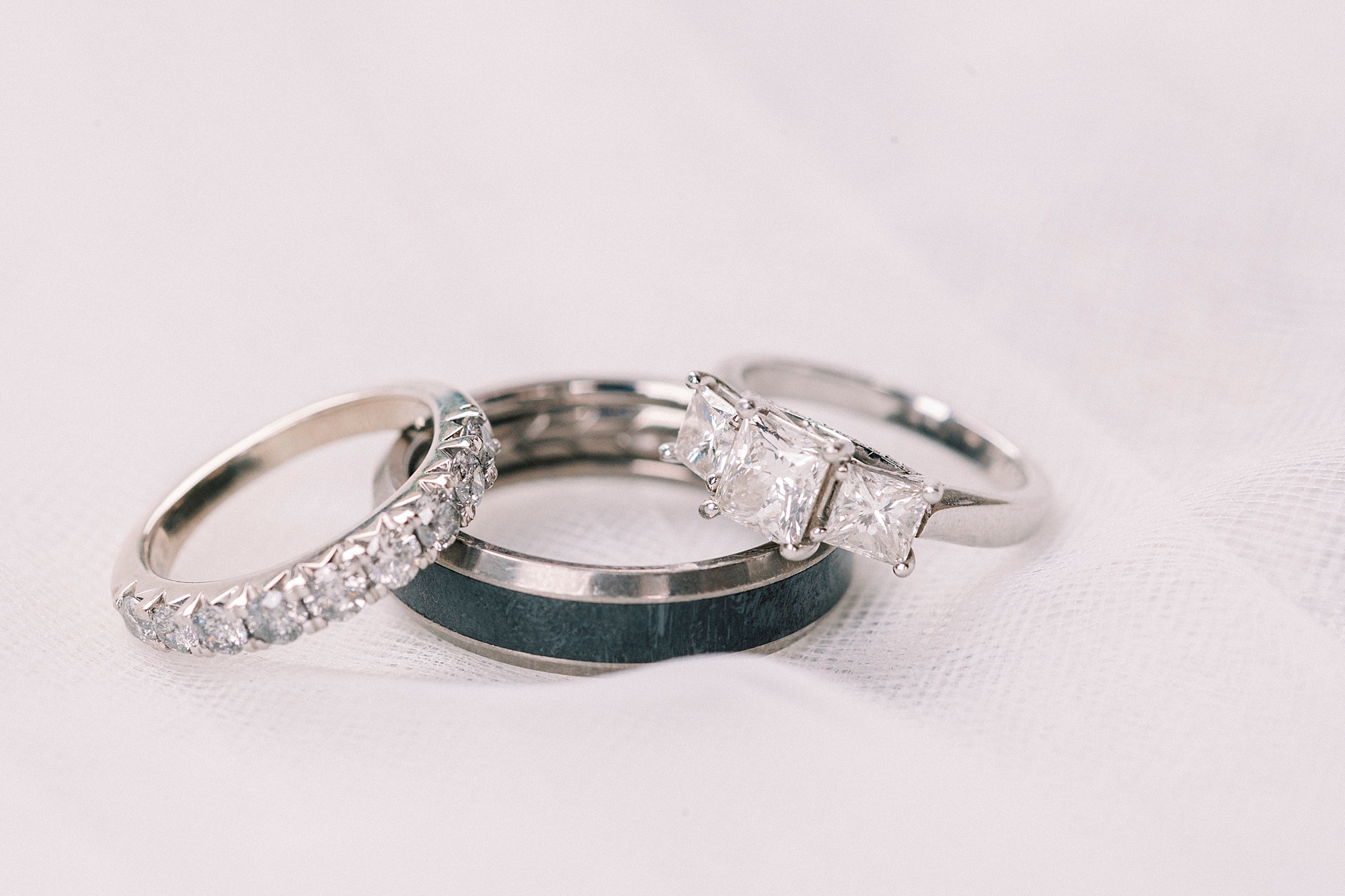 wedding rings stacked together on veil