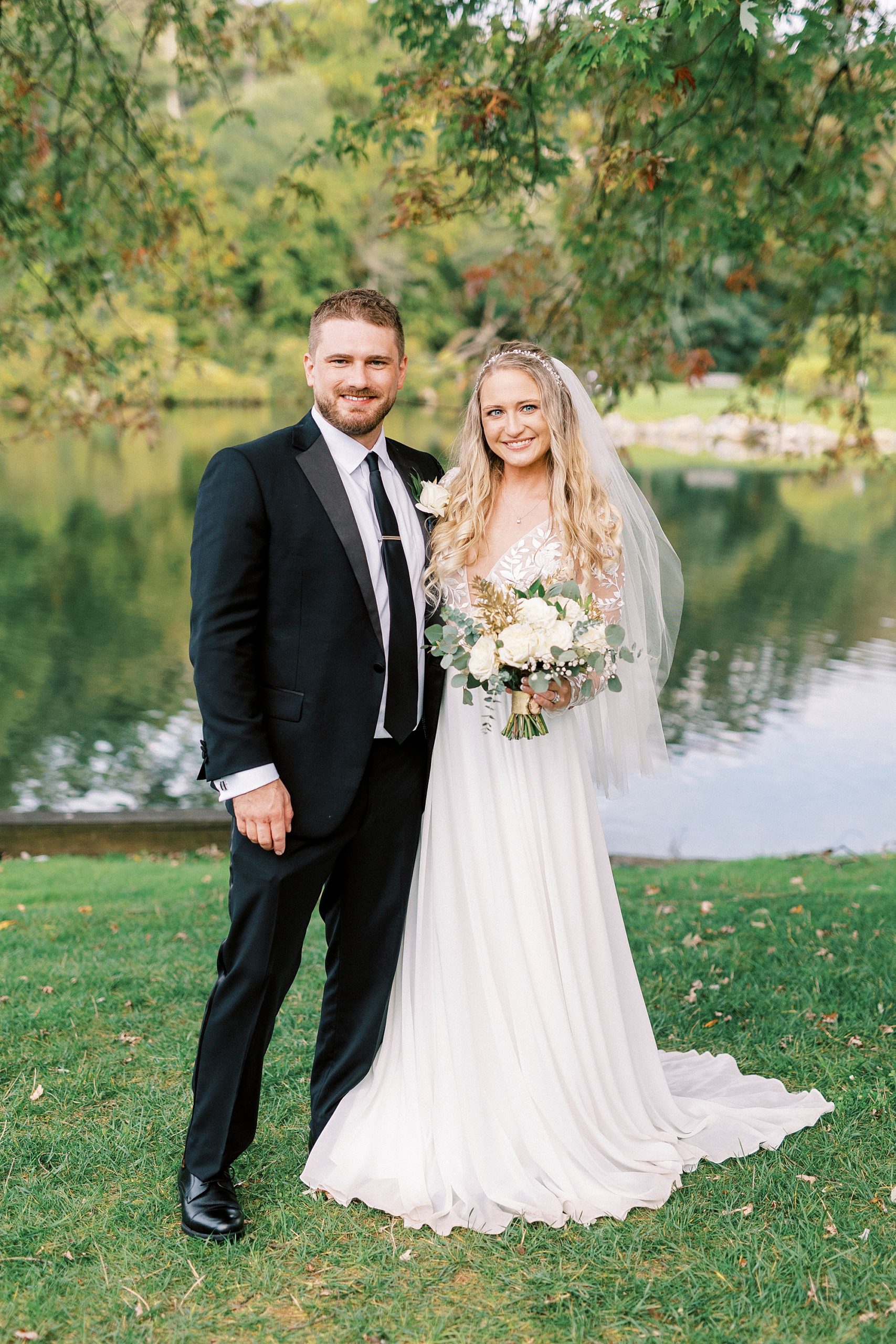 newlyweds stand together during fall wedding portraits