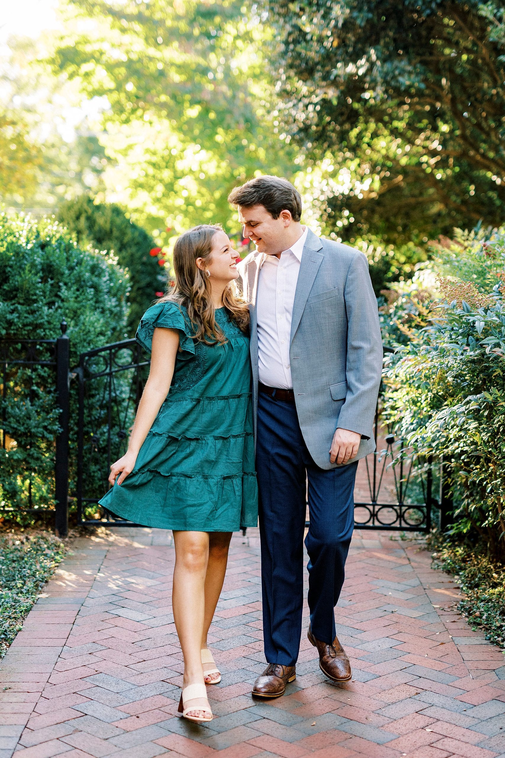 bride and groom hug walking down brick pathway at Downtown Davidson