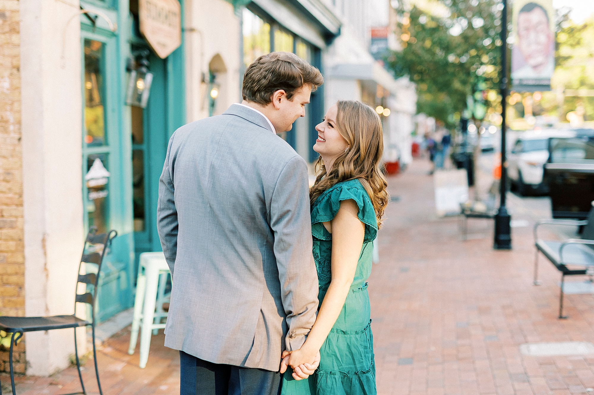 couple holds hands in street of Downtown Davidson