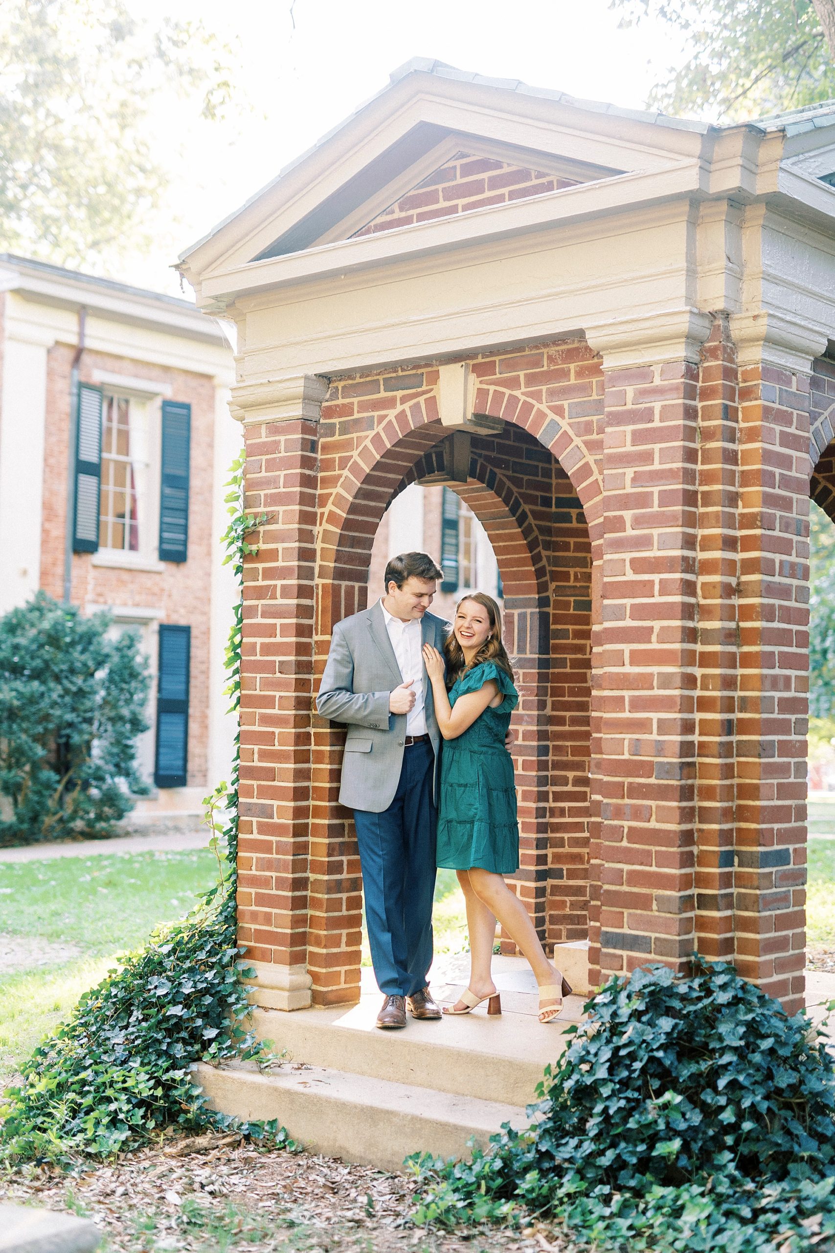 bride leans into groom during portraits at Downtown Davidson brick gazebo