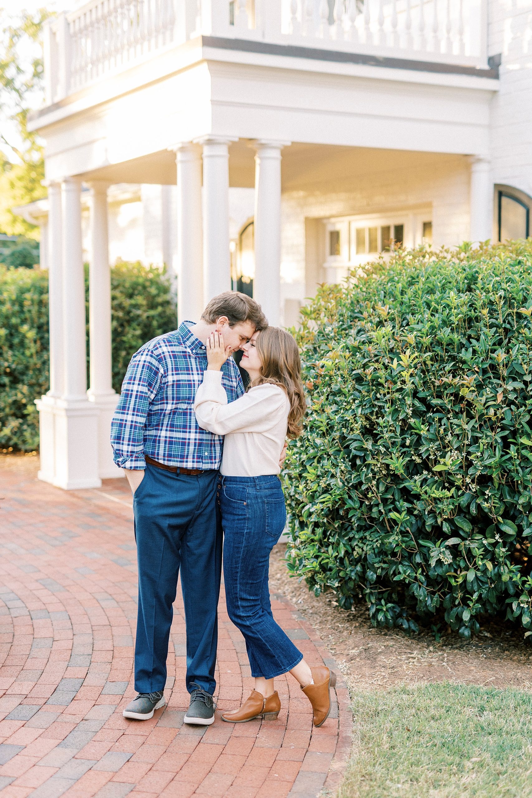 bride and groom hug outside white awning in Downtown Davidson