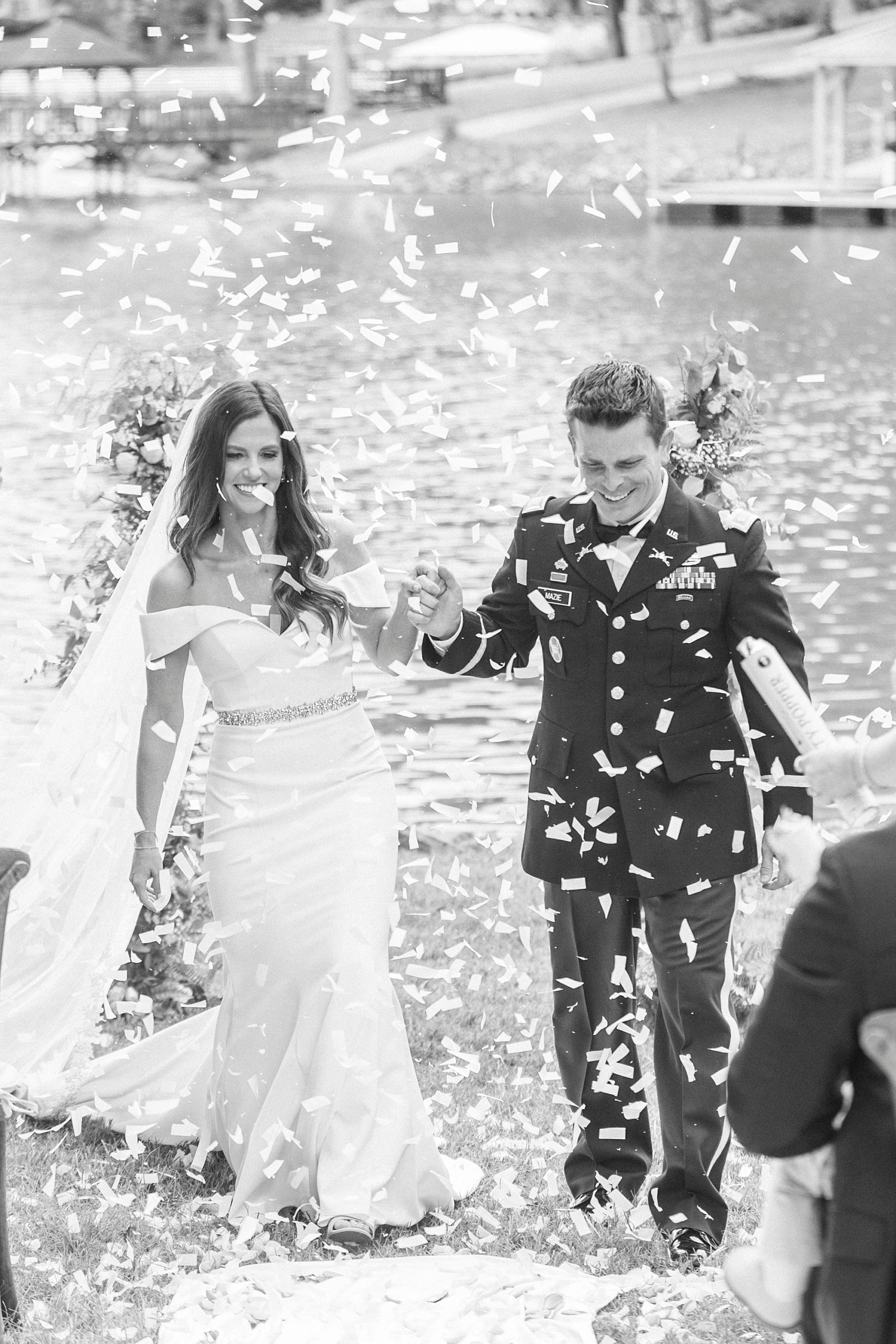 bride and groom walk through rose petals being thrown by guests after ceremony