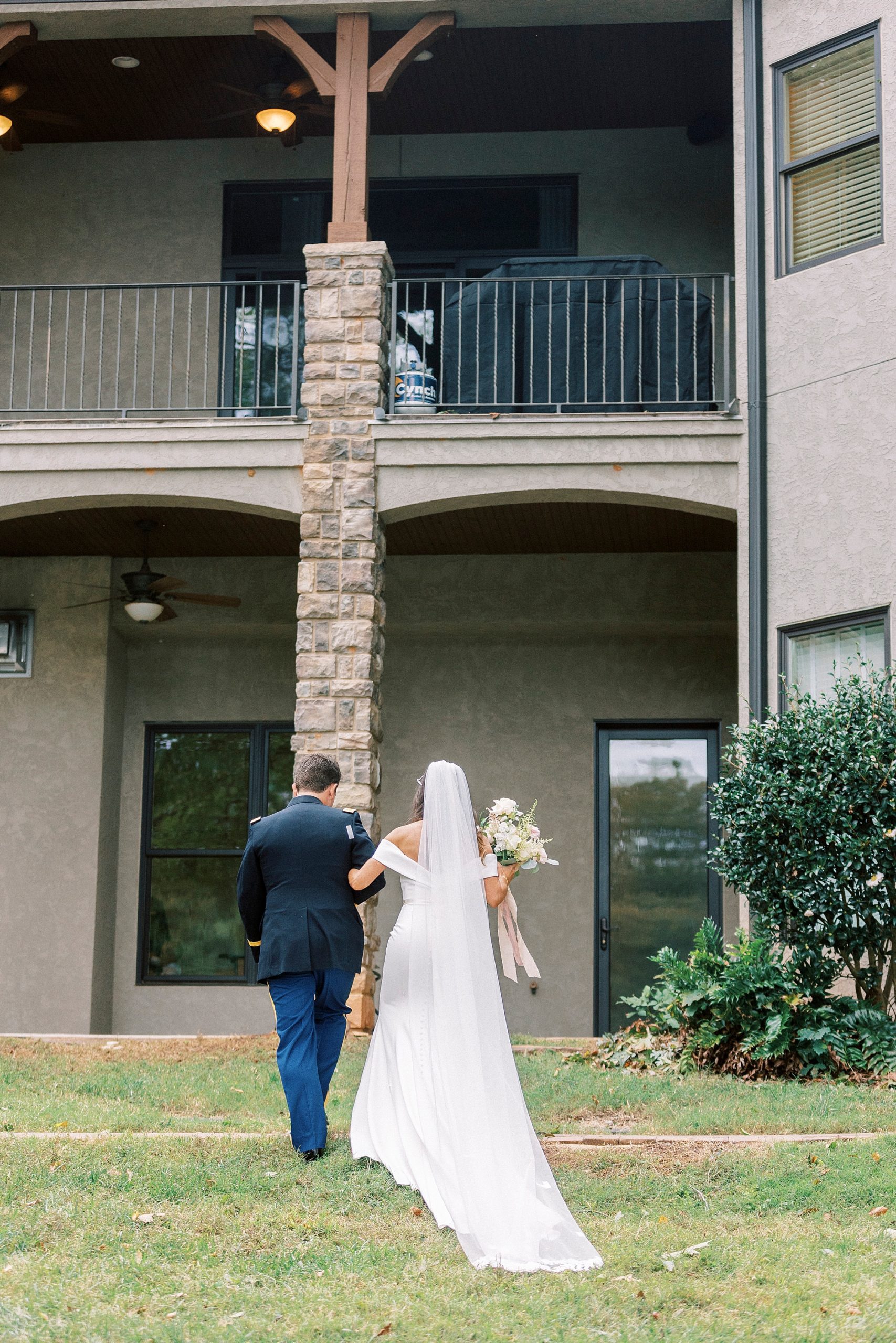 bride and groom walk towards Lake Norman house