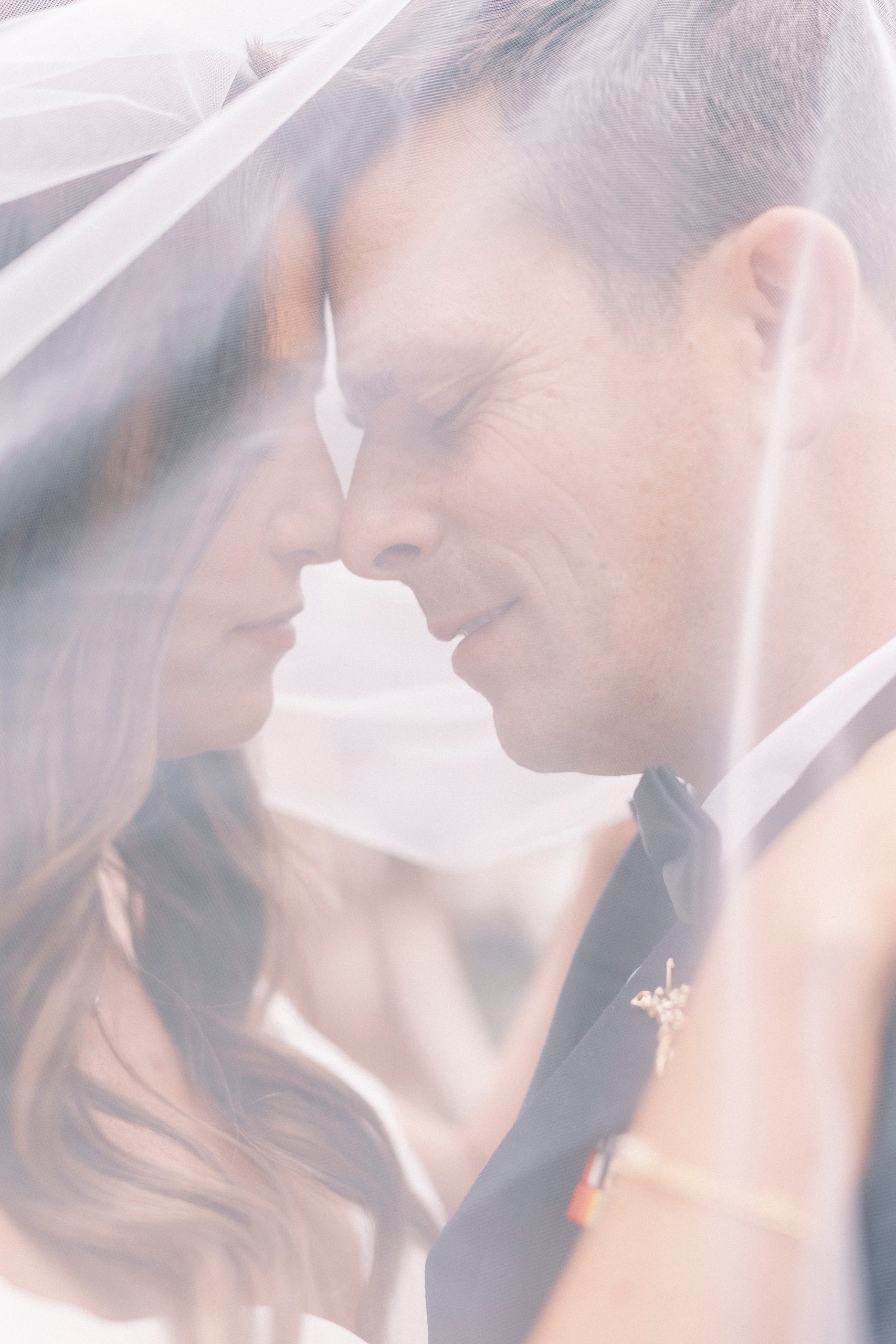 bride and groom hug under veil during NC wedding portraits