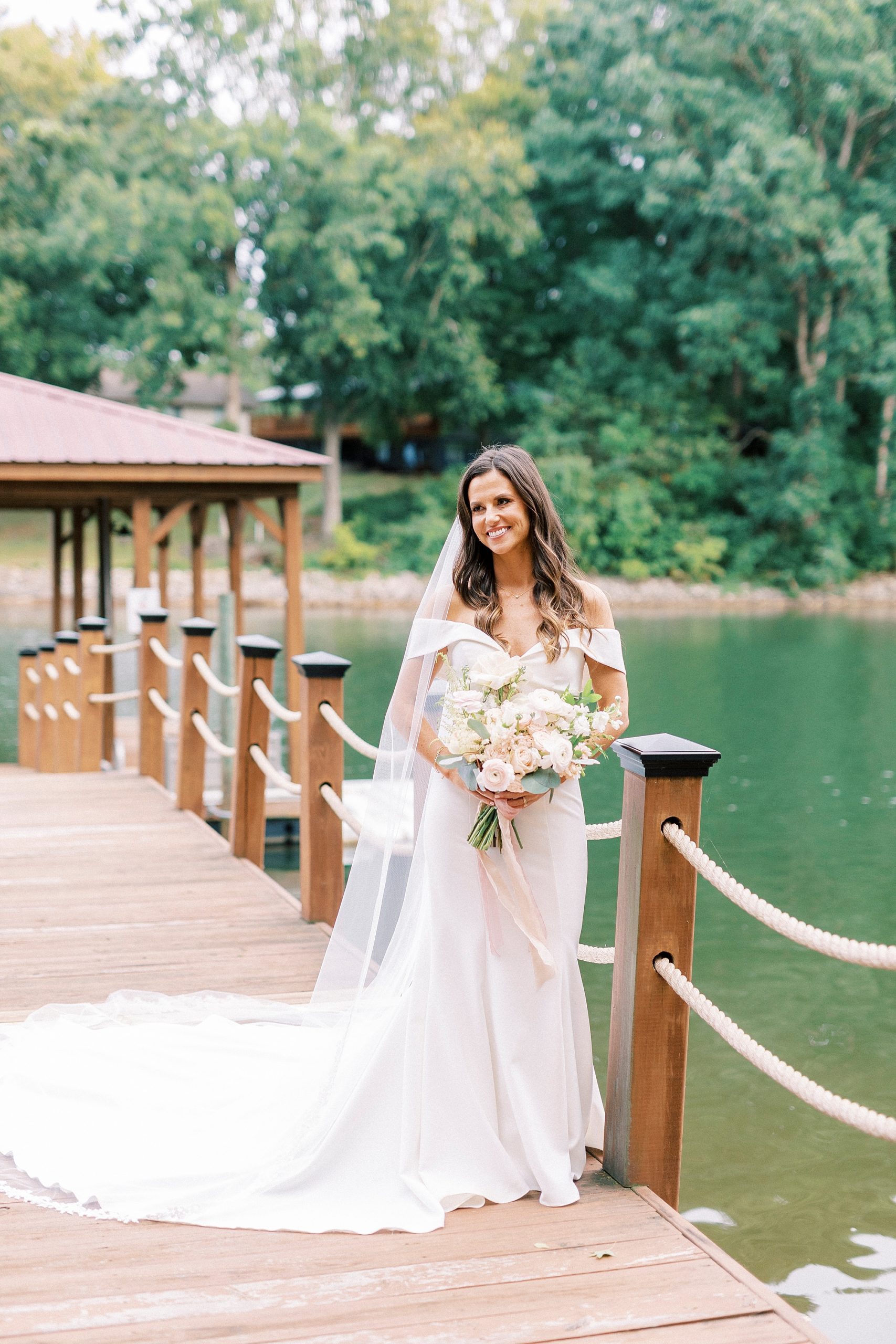 bride smiles leaning over shoulder during portraits at Lake Norman