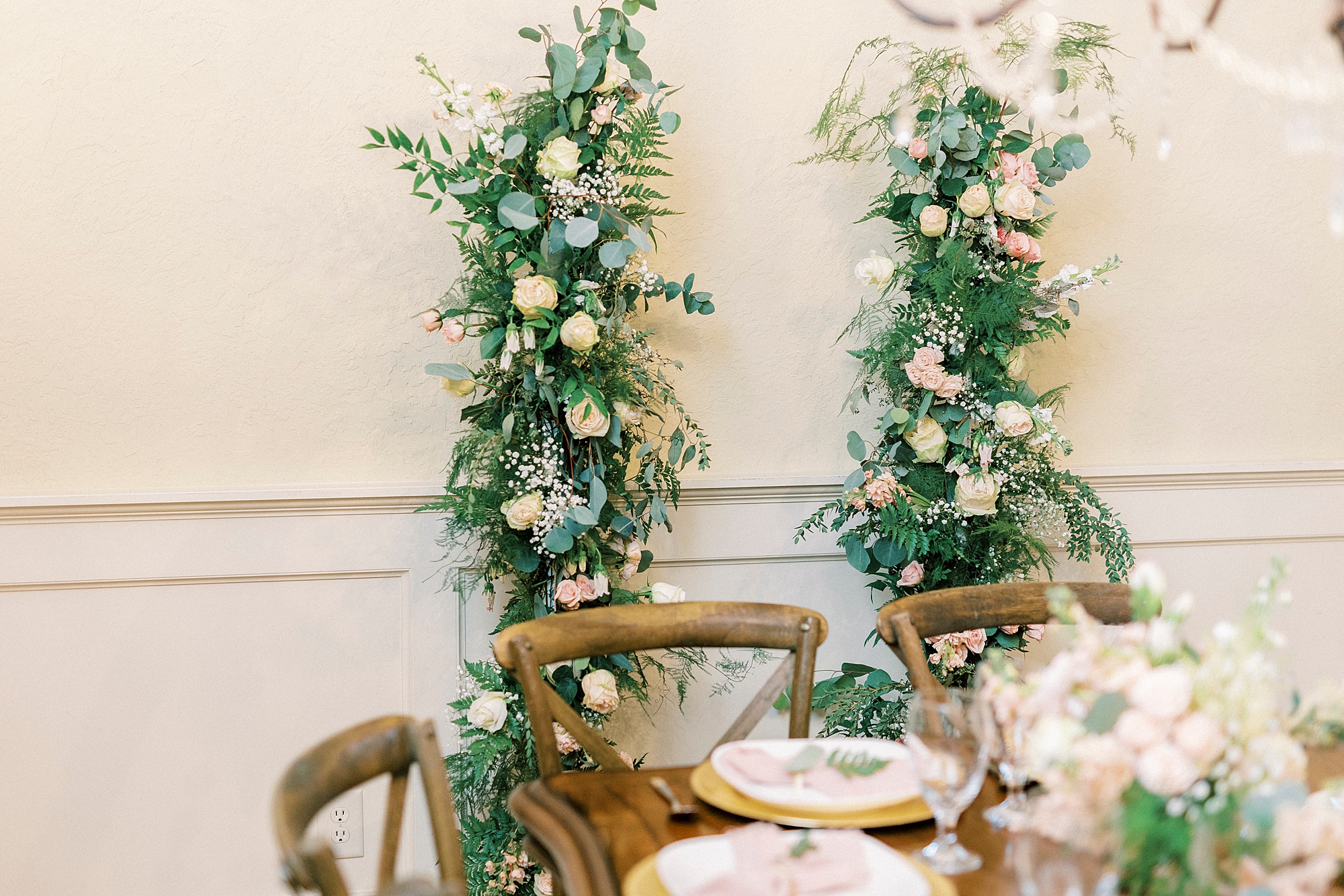 floral display sits behind table for reception