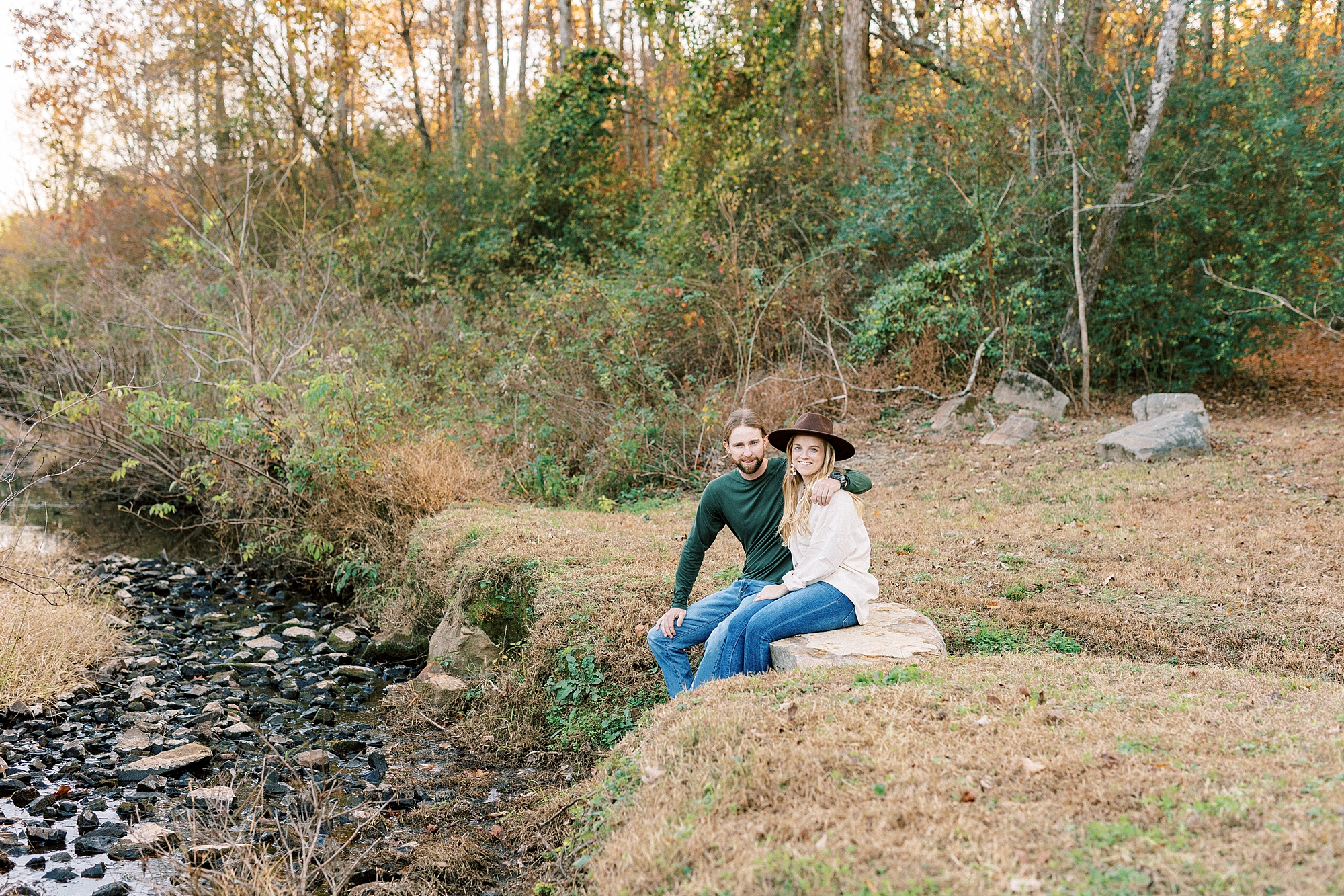 engaged couple sits by creek near Richfield NC home