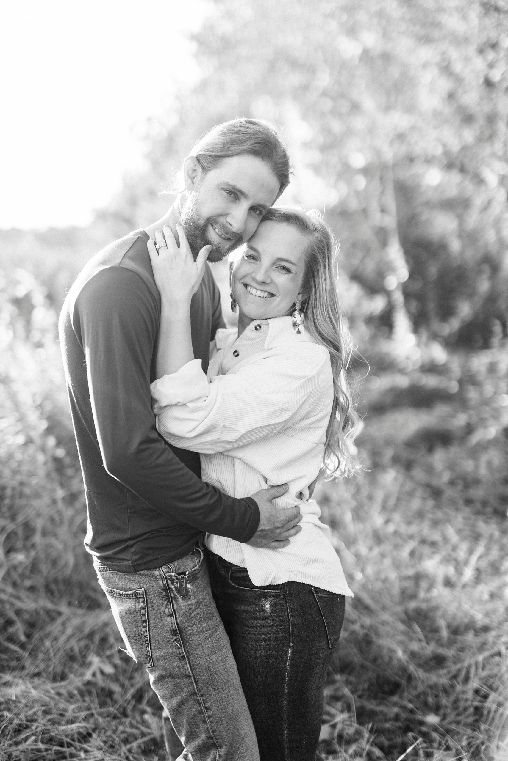 bride leans into groom hugging him during chic fall engagement session