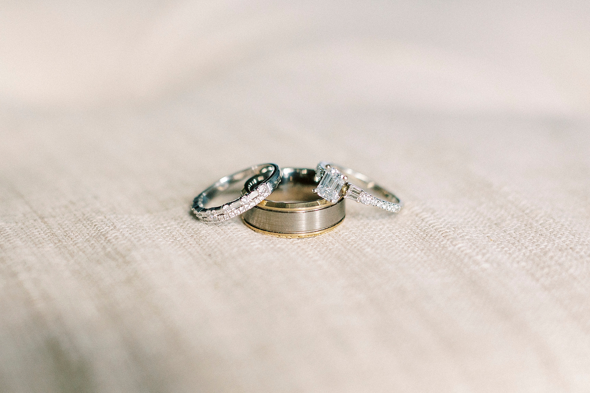 gold wedding bands lay on grey backdrop 