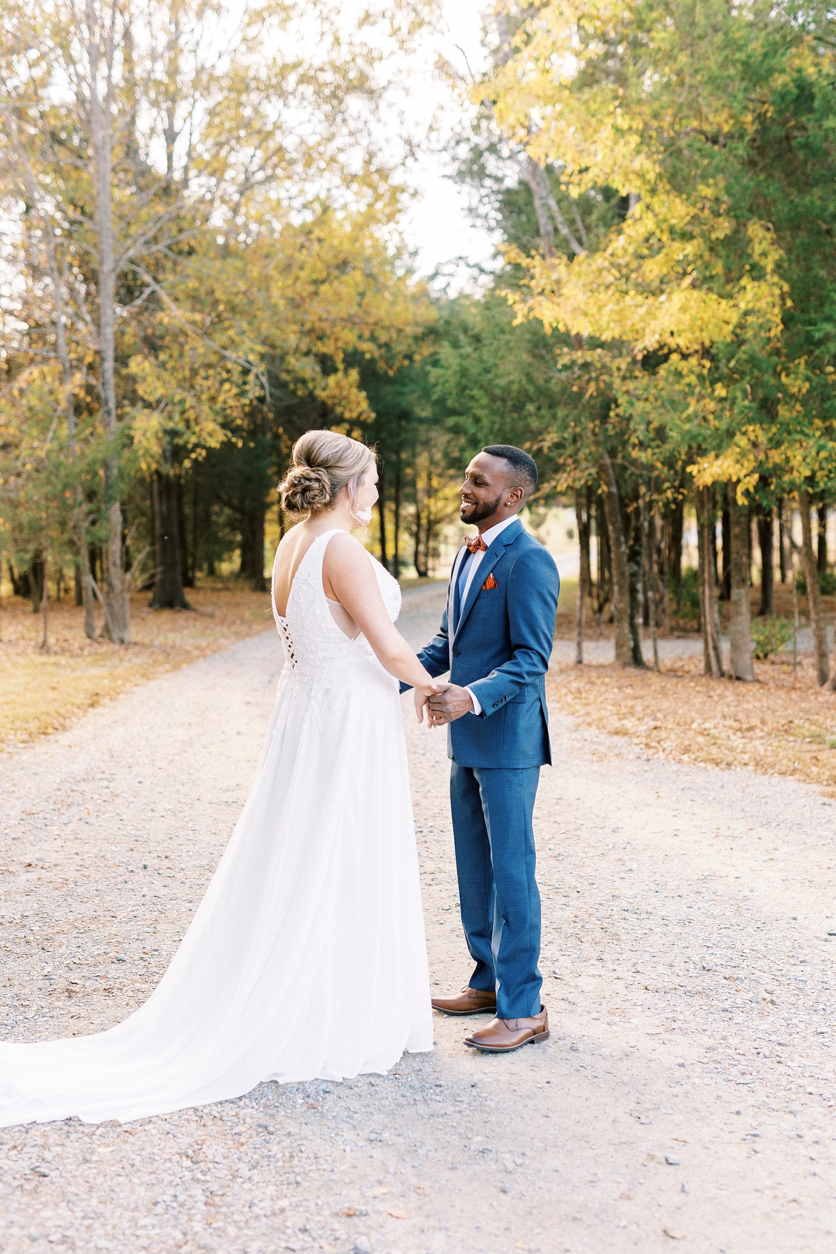 newlyweds hold hands smiling together during first look at Bella Terra 