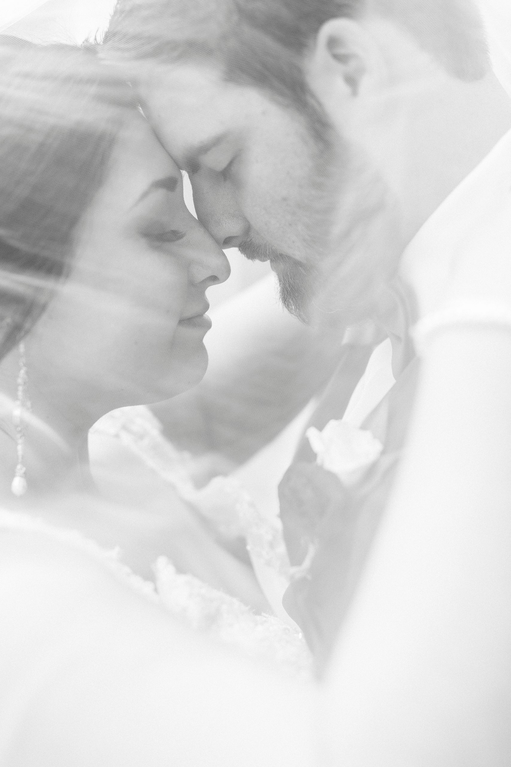 newlyweds hug under bride's veil