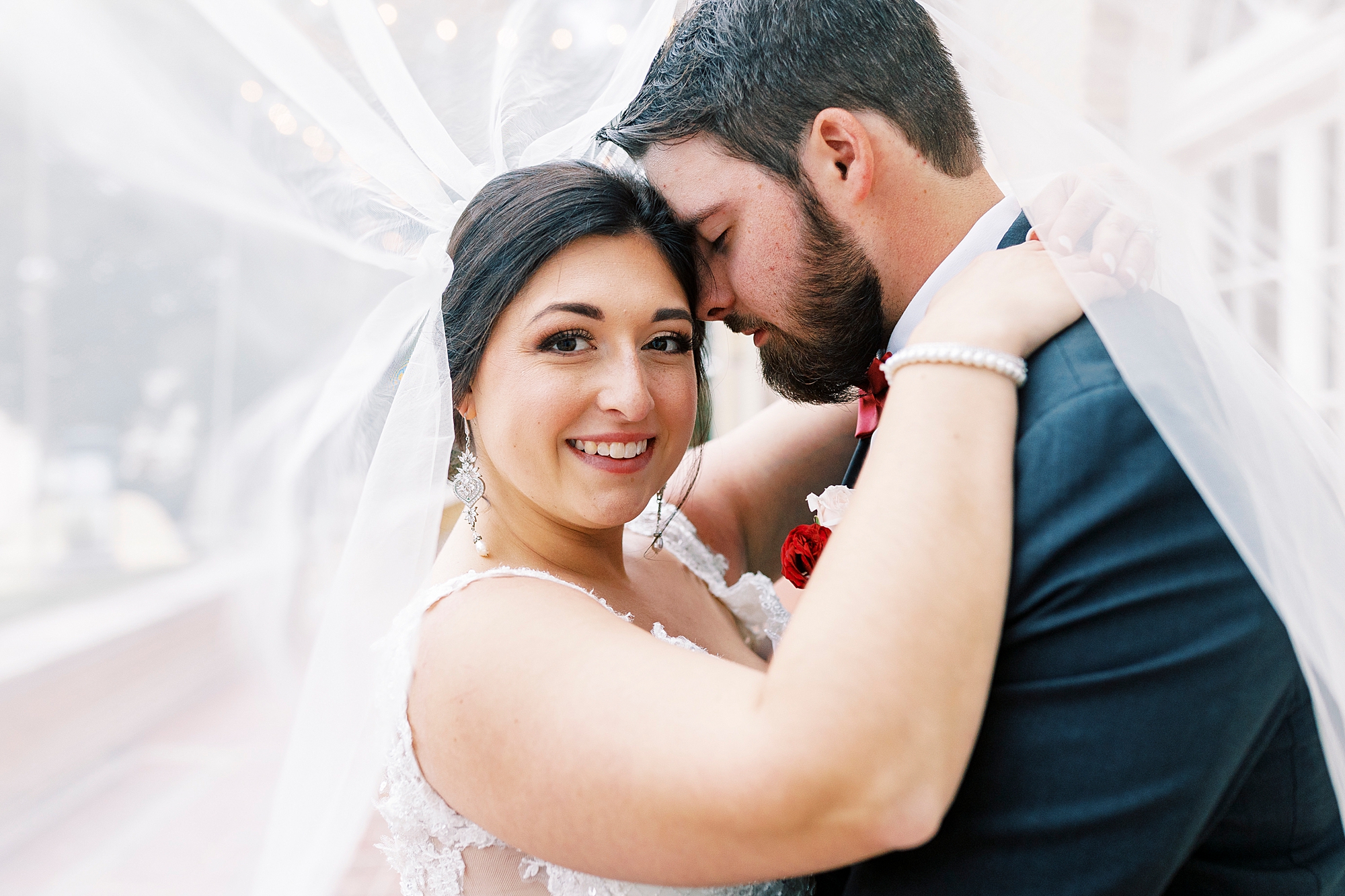 groom nuzzles bride's cheek under veil