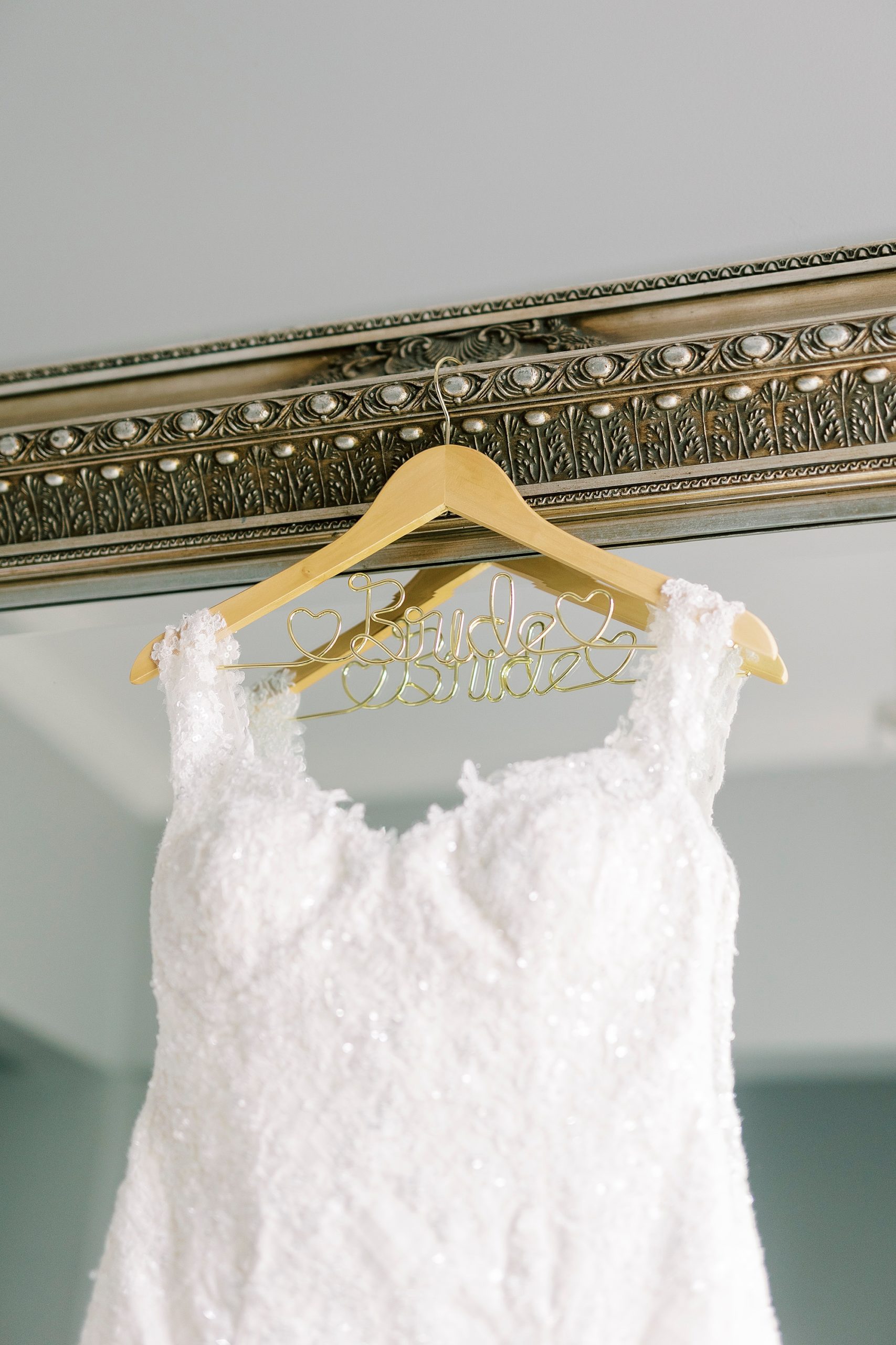 wedding dress hangs on gold mirror in bridal suite at Separk Mansion