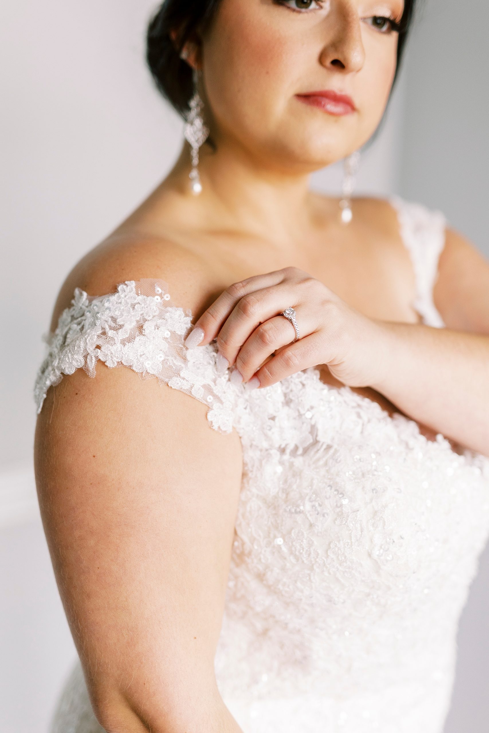 bride adjusts lace sleeve of wedding gown in bridal suite at Separk Mansion
