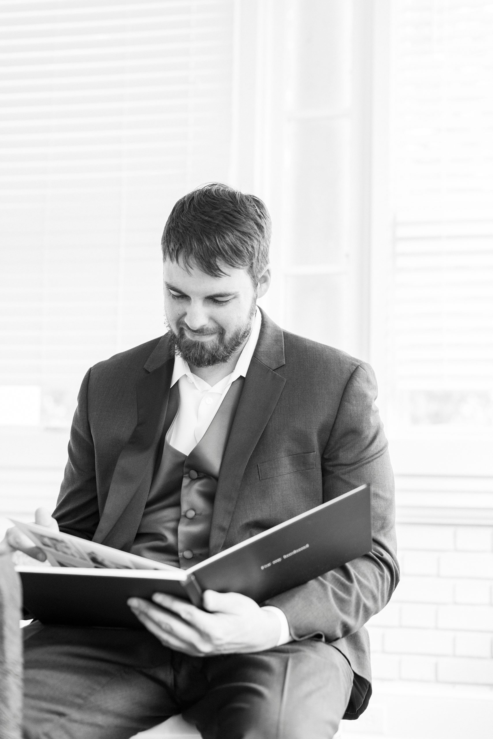 groom smiles looking at gift from bride