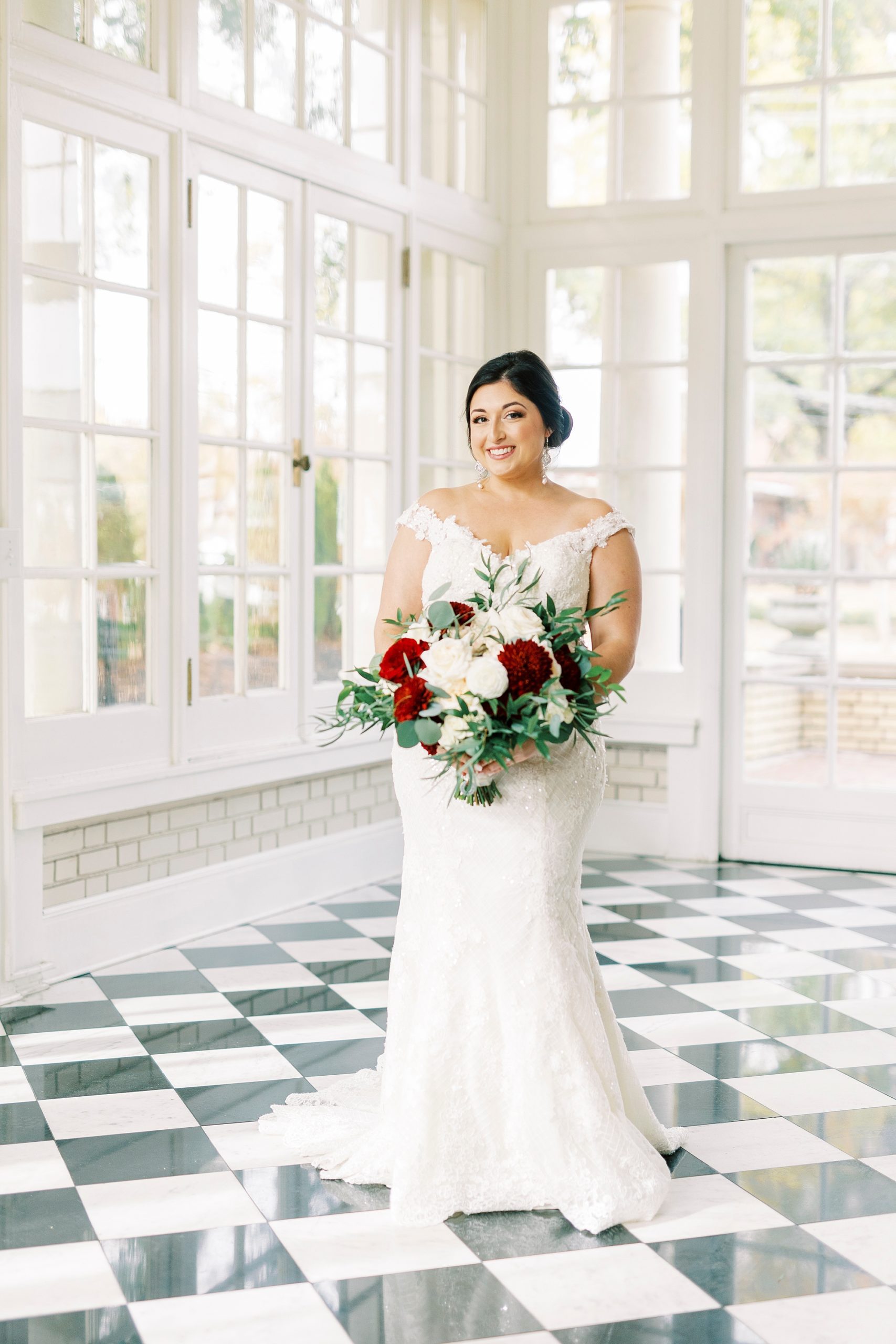bride smiles holding bouquet of pink and red flowers in Separk Mansion