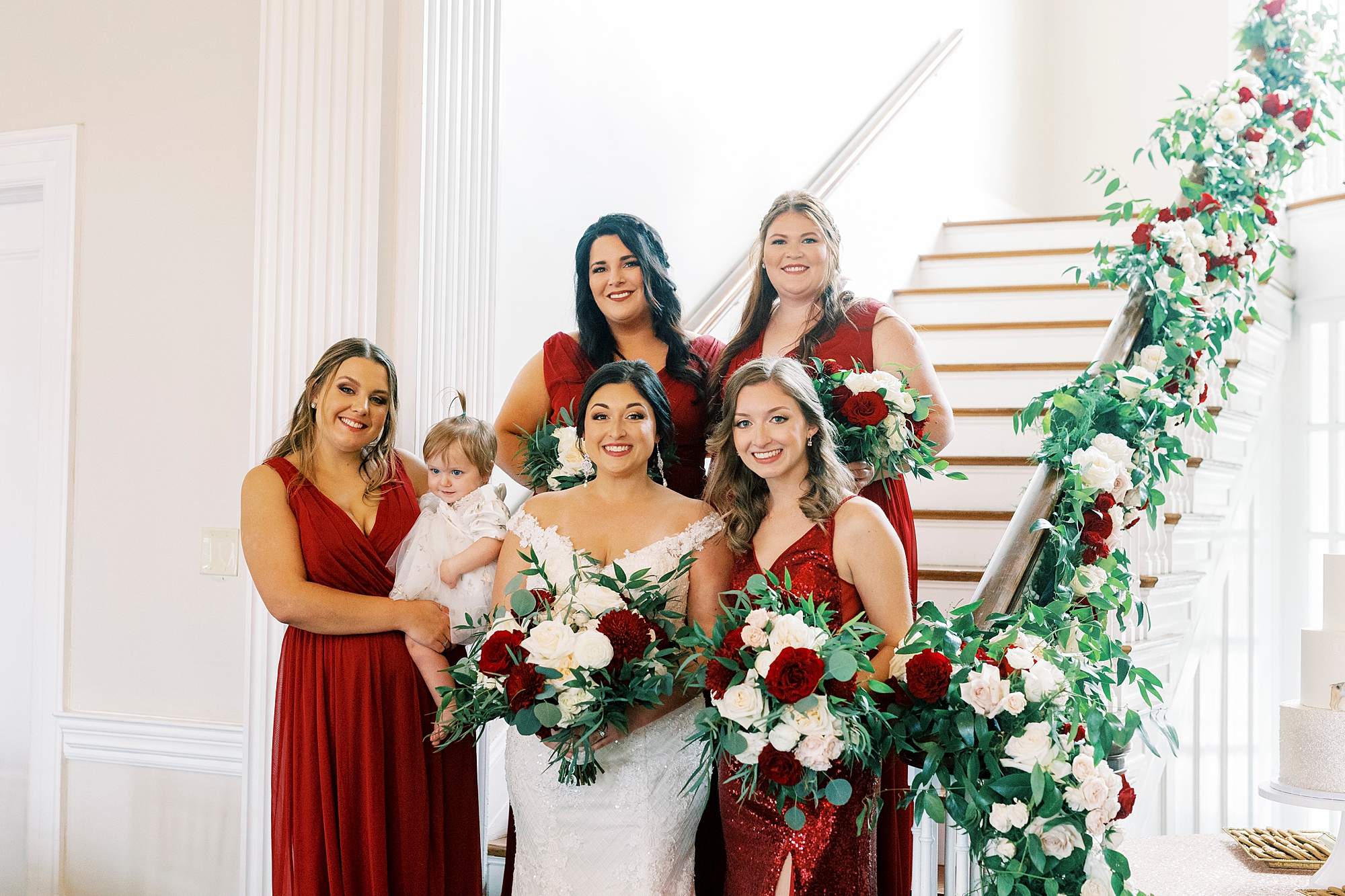 bride and bridesmaids pose on staircase inside Separk Mansion