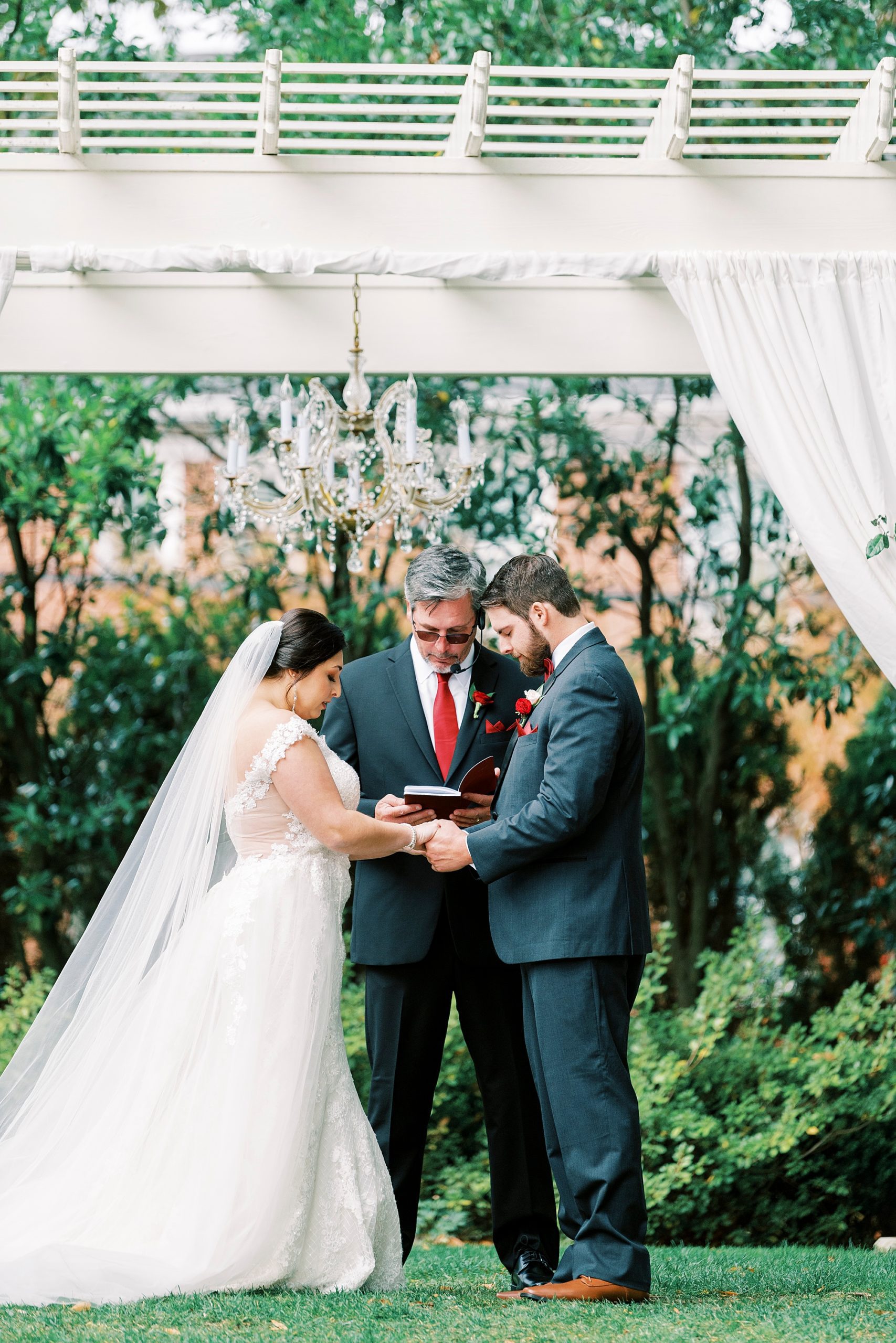 bride and groom hold hands during outdoor wedding ceremony at Separk Mansion