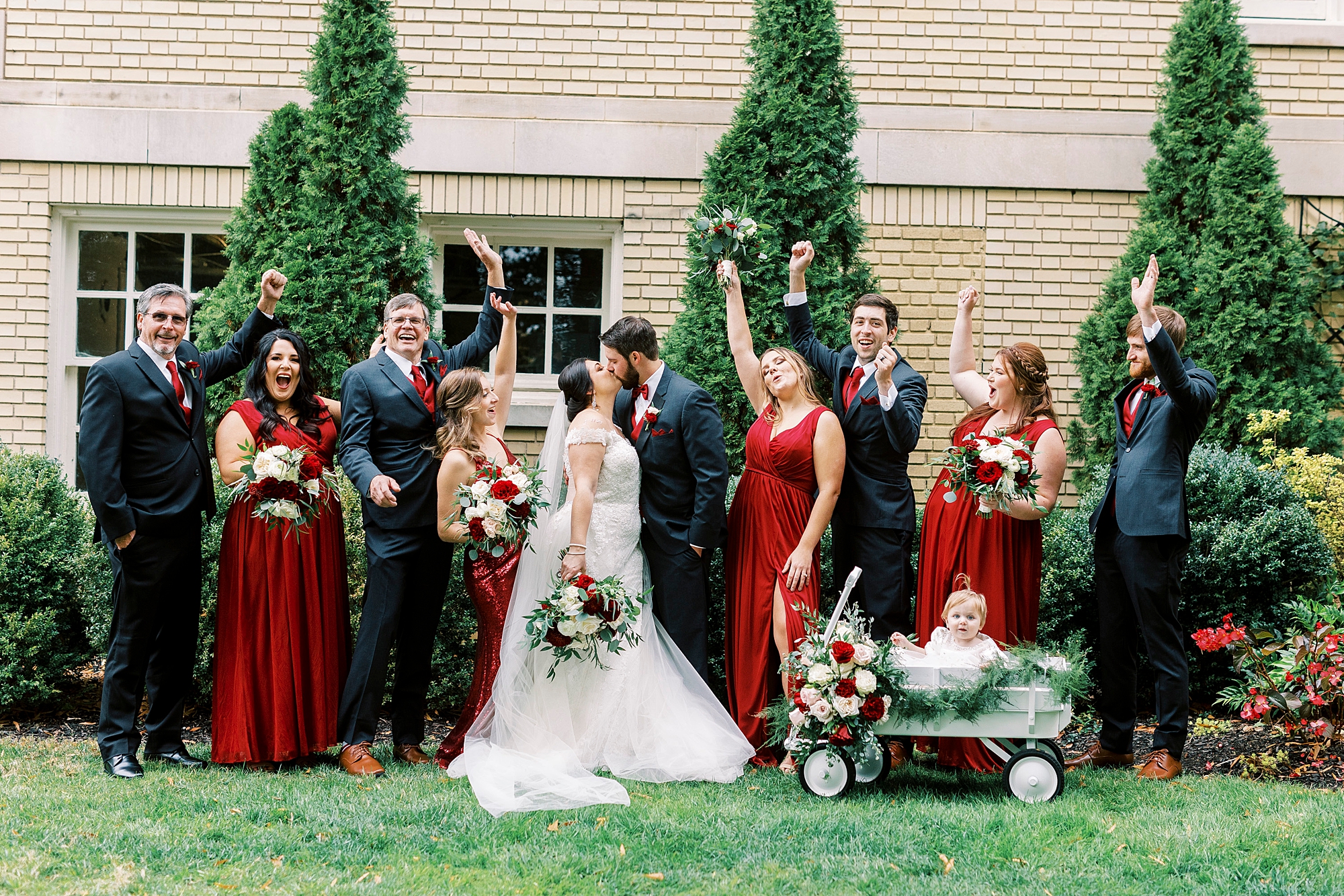newlyweds kiss while wedding party cheers