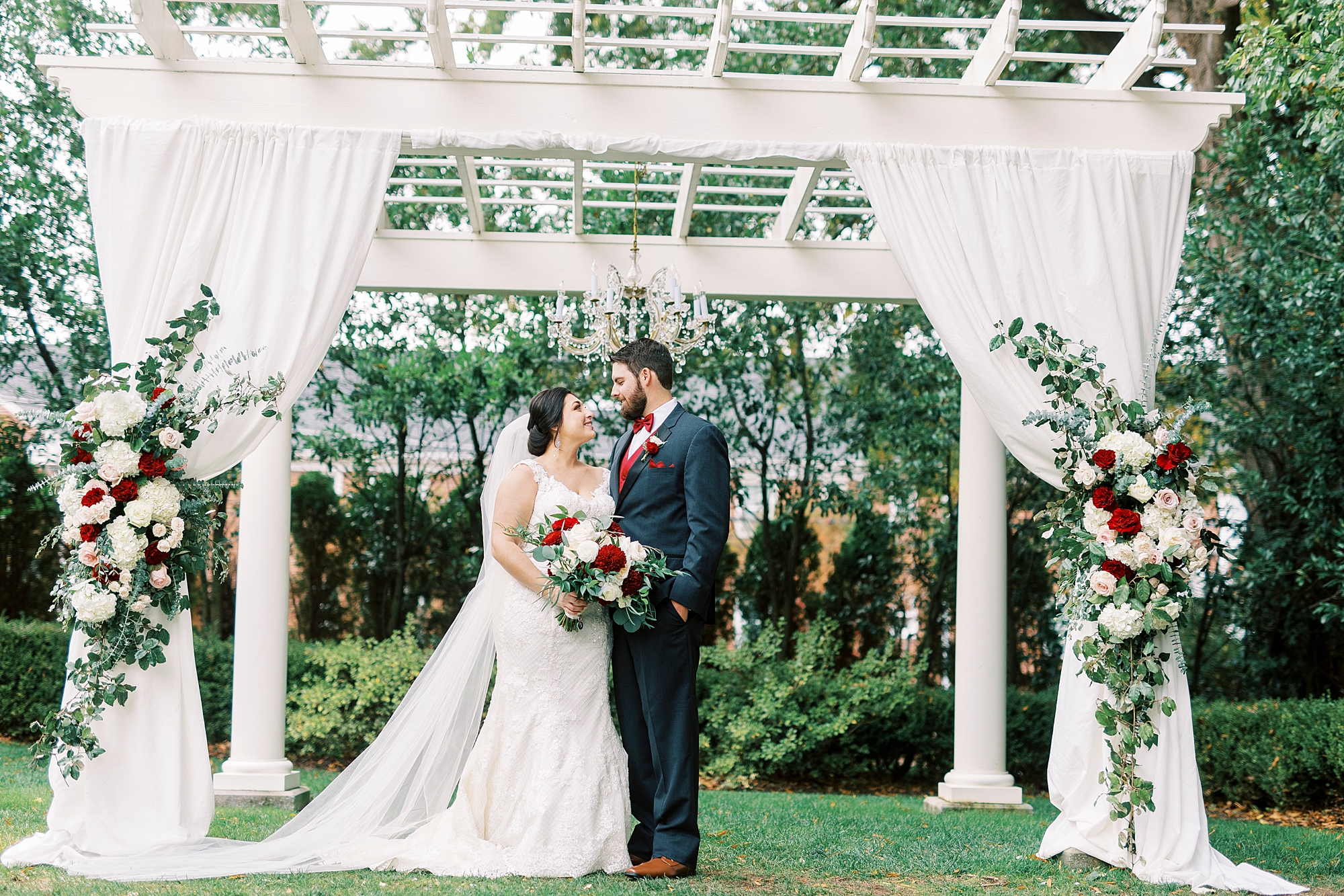 bride and groom hug under white arbor at Separk Mansion