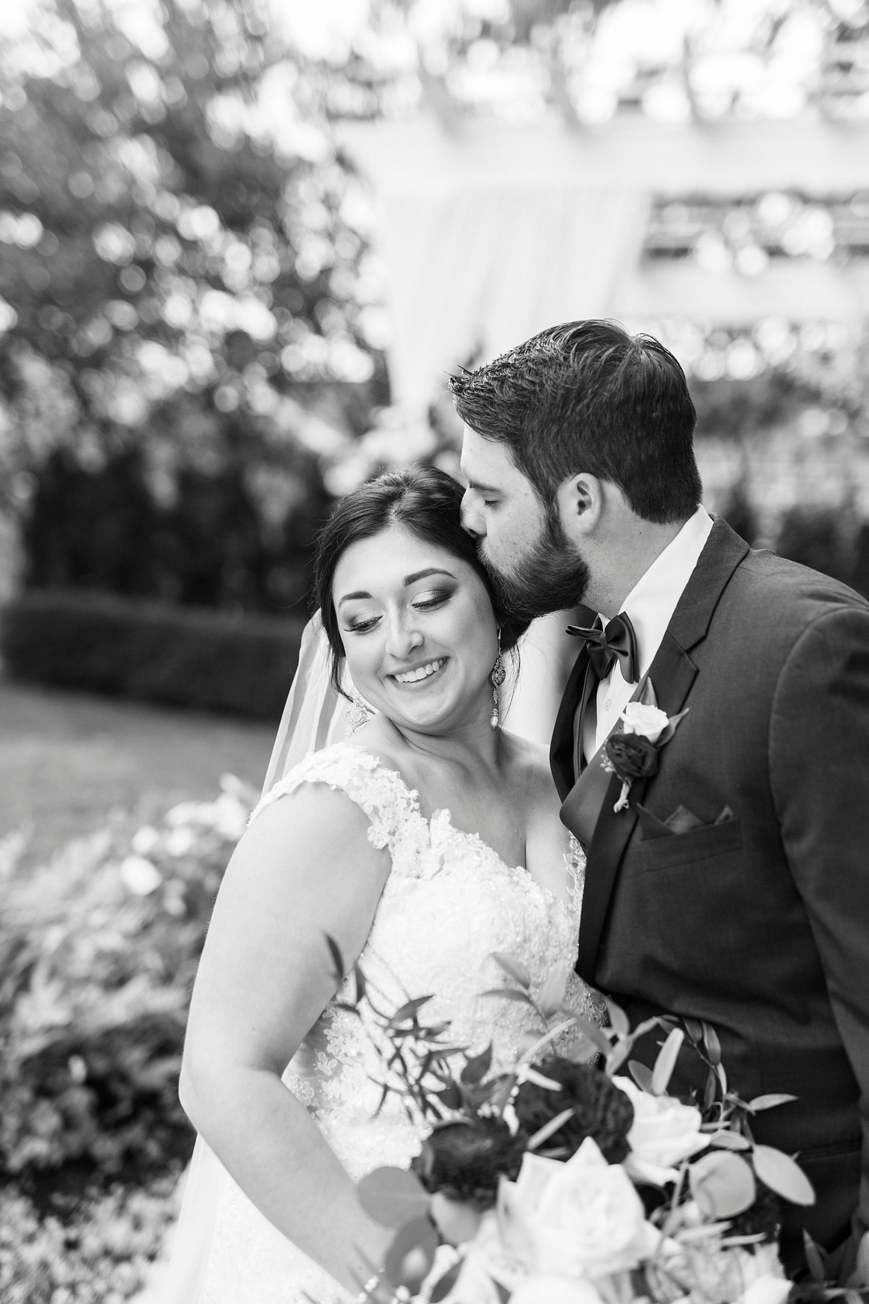 groom kisses bride's forehead hugging her during fall wedding at Separk Mansion