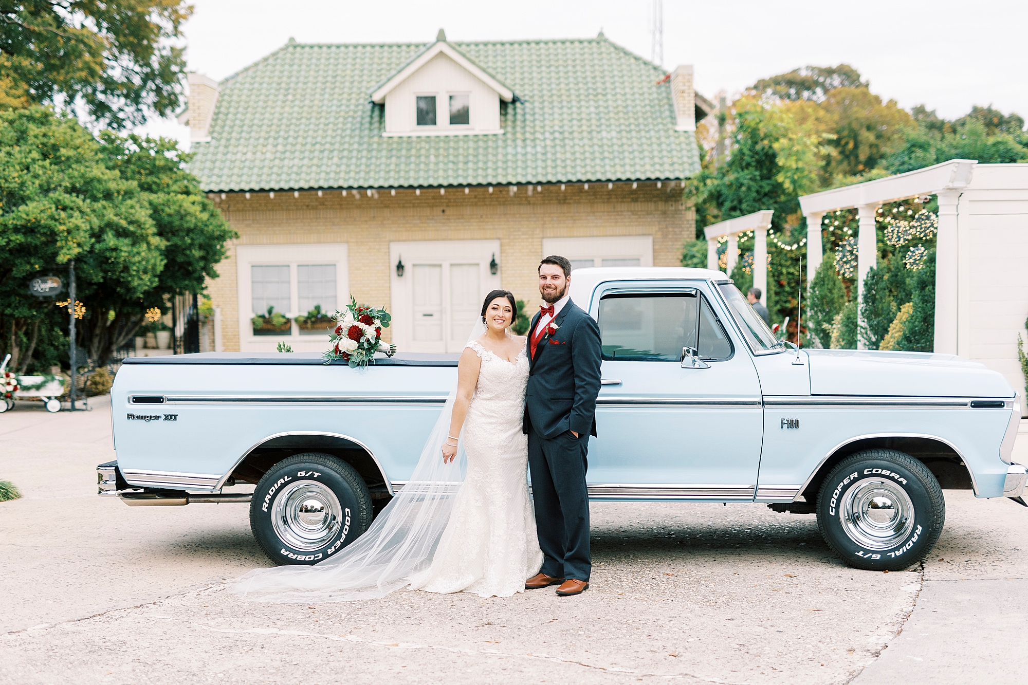 bride and groom hug by resorted blue Ford truck at Separk Mansion