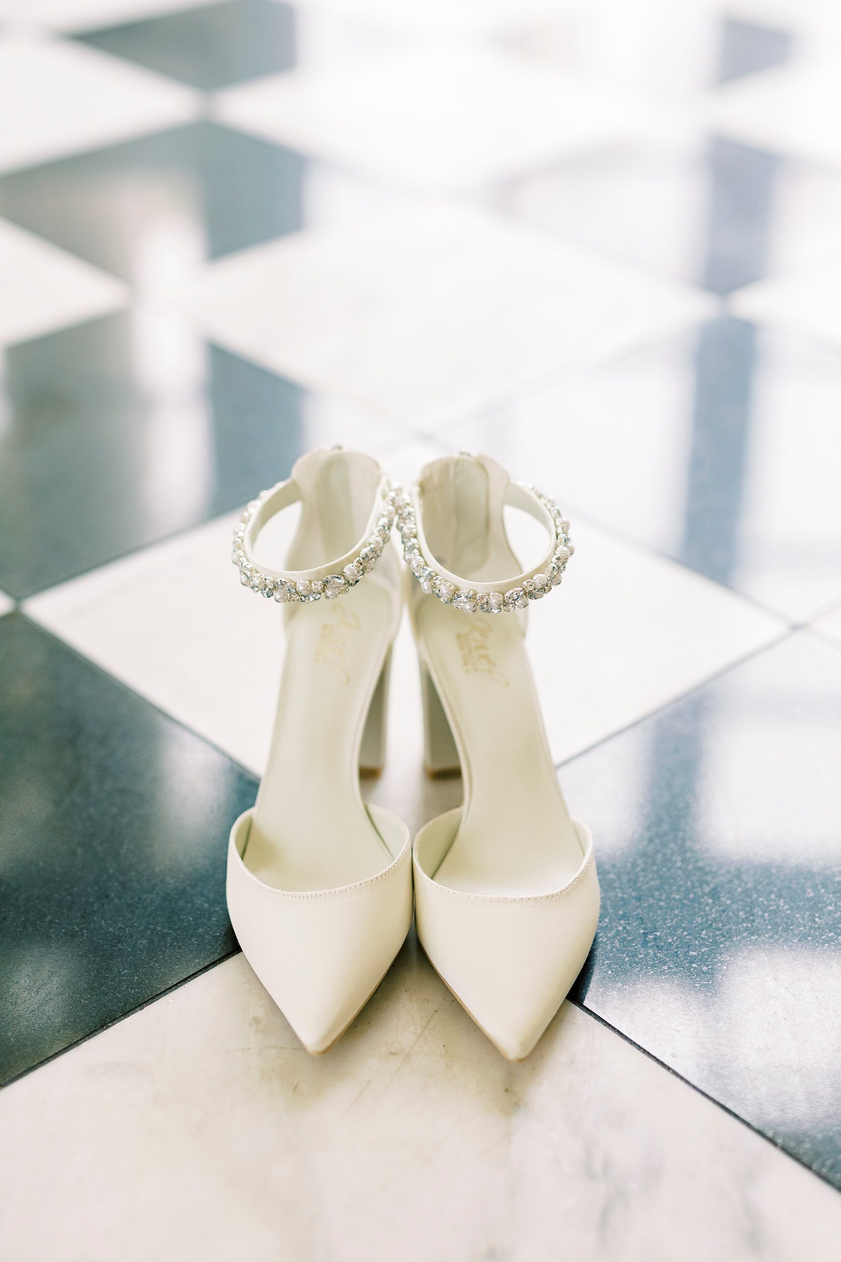 bride's white shoes rest on black and white floor at Separk Mansion