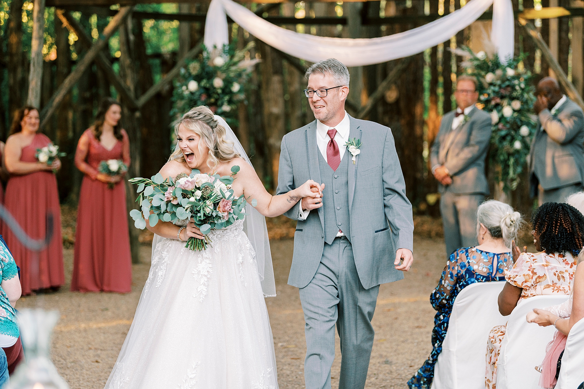 bride and groom cheer walking up aisle at the Gin at Aw Shucks Farm