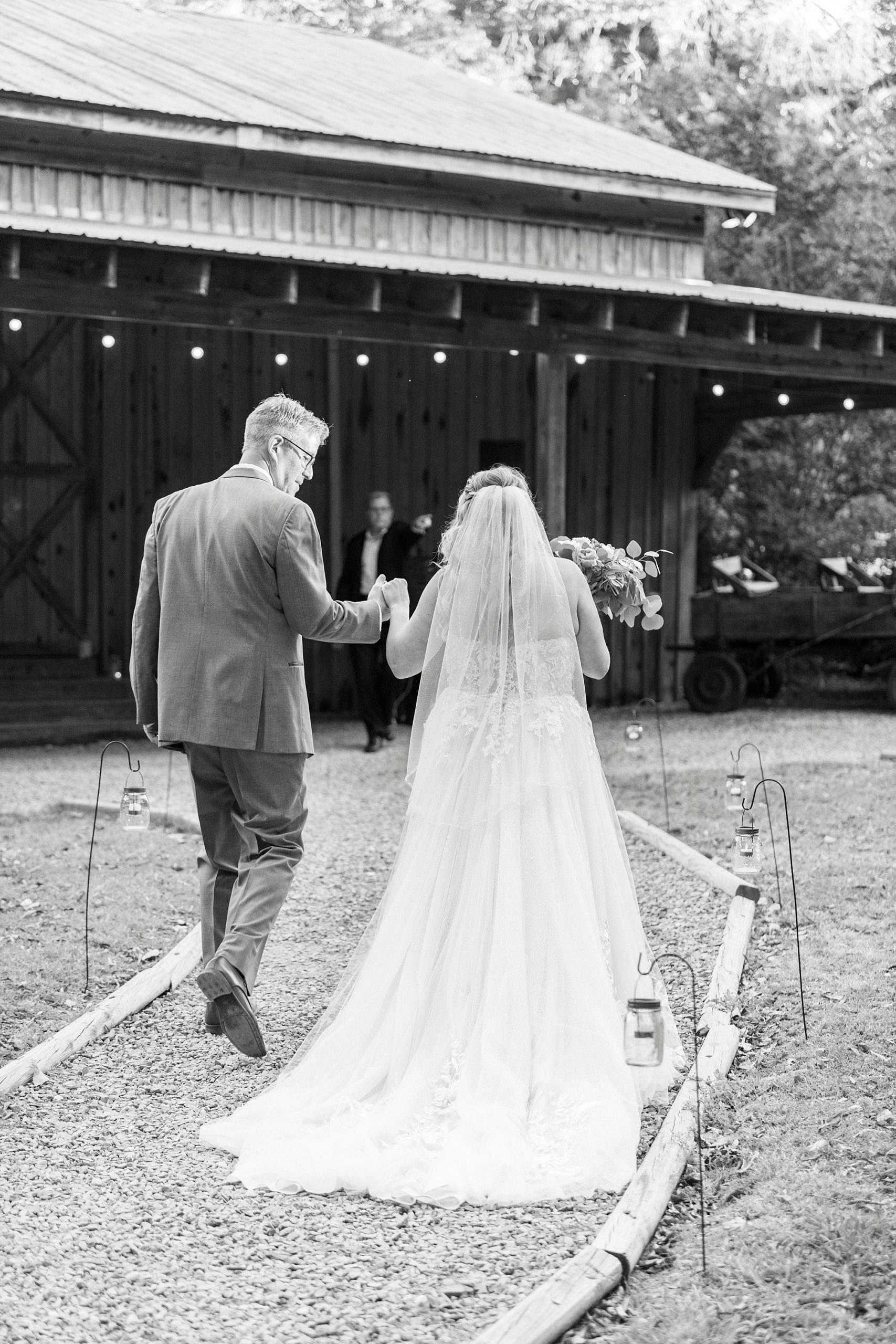 groom holds bride's hand leading her towards reception