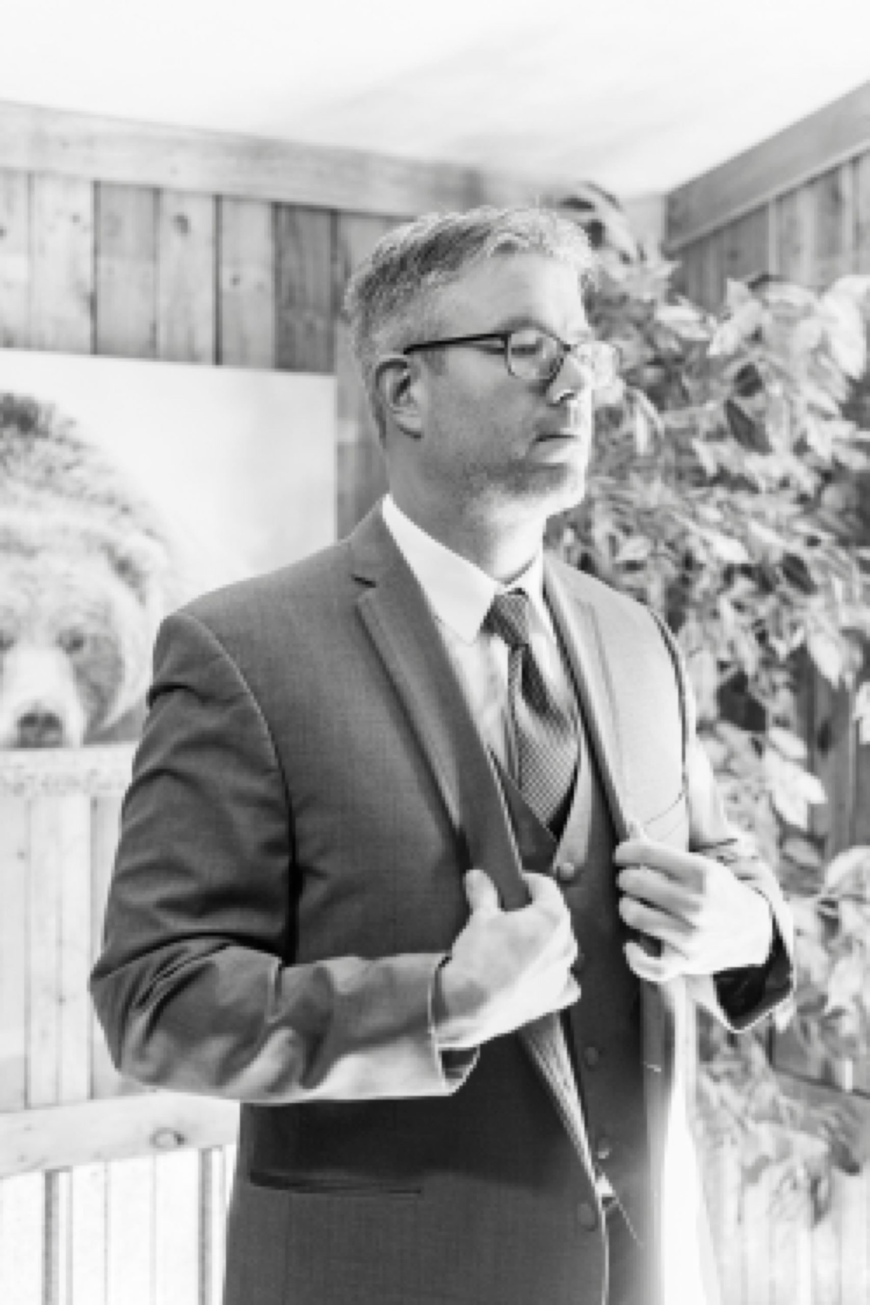 groom adjusts suit jacket preparing for Monroe NC wedding day