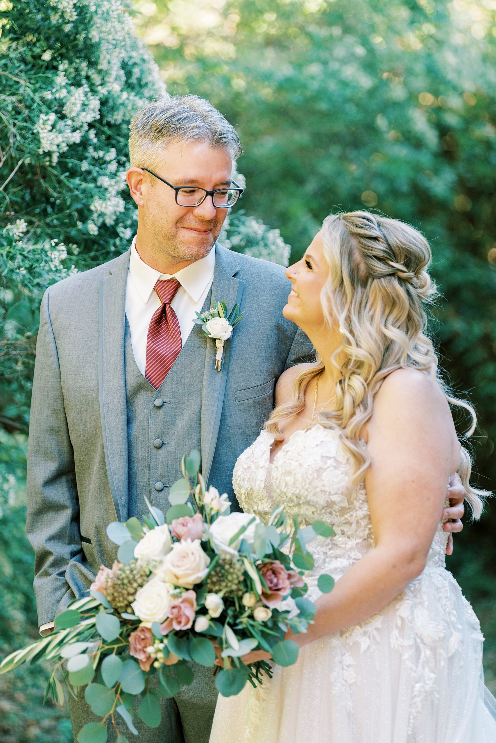 bride and groom smile up at each other during portraits at the Gin at Aw Shucks Farm