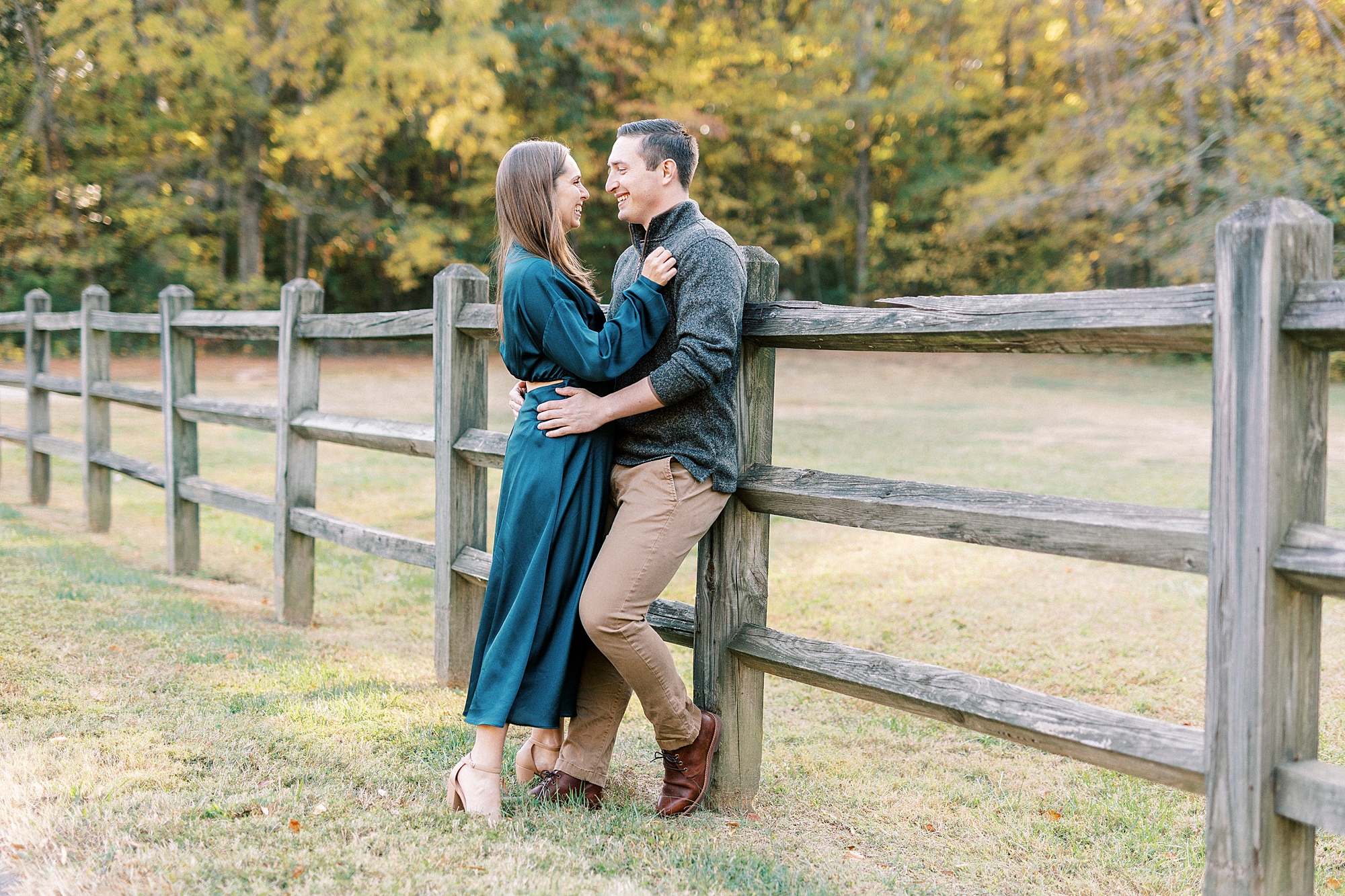 bride and groom lean against wooden fence pole at Latta Nature Preserve