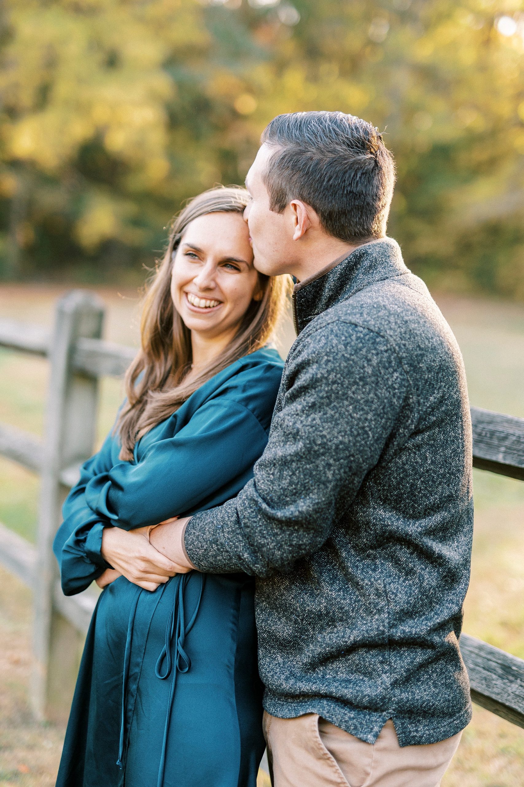 groom kisses bride's forehead during fall engagement session at Latta Nature Preserve