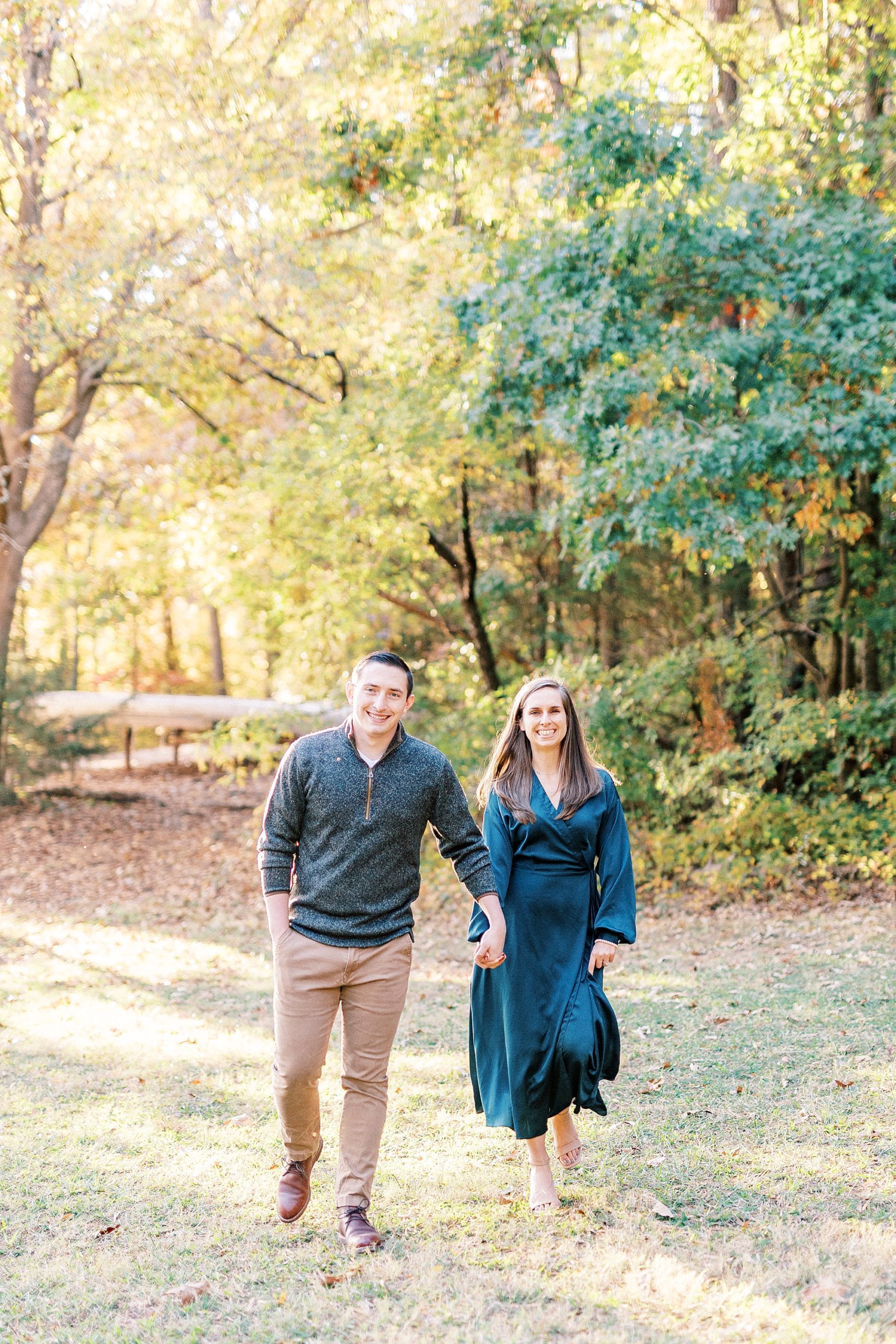bride and groom hold hands walking through field at Latta Nature Preserve