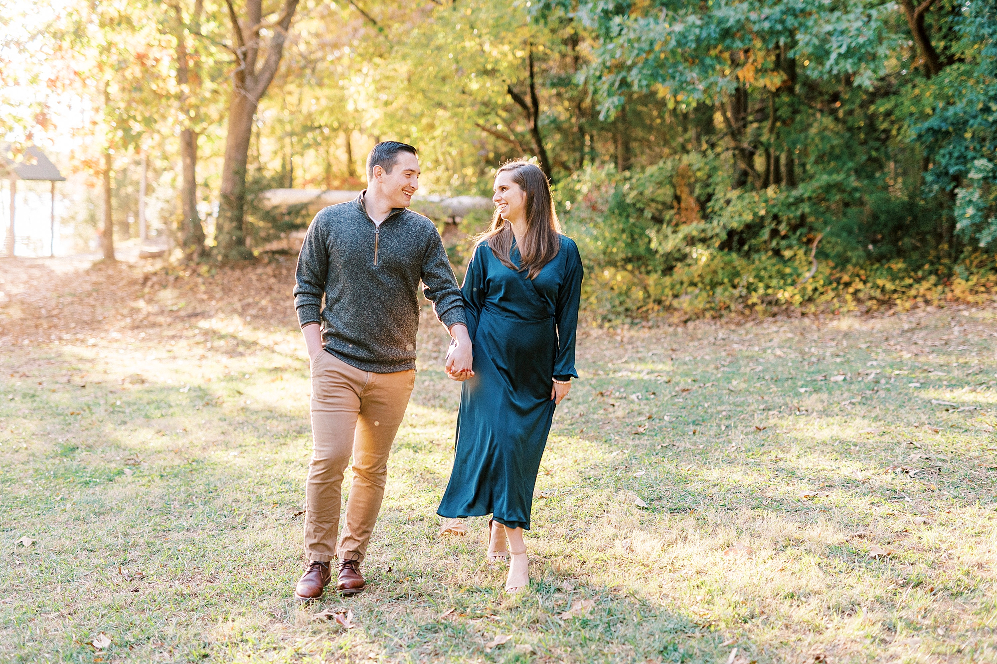 couple holds hands walking together through field at Latta Nature Preserve