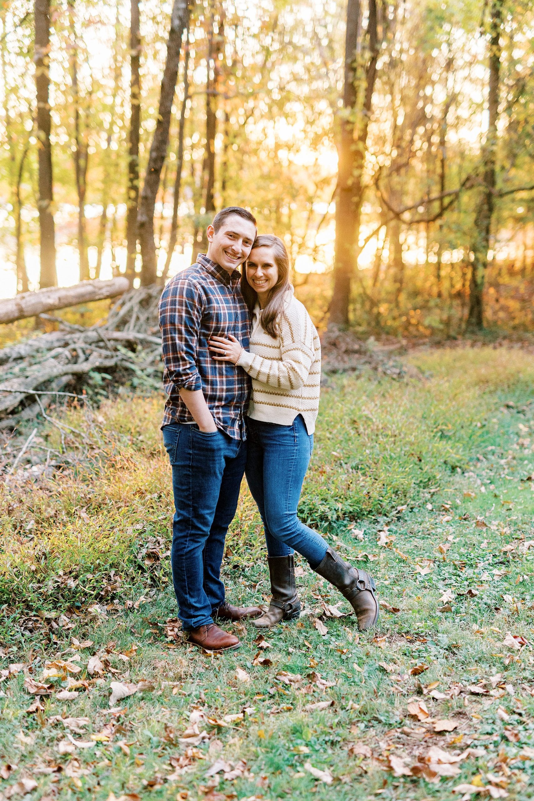 bride and groom hug at sunset along wood line at Latta Nature Preserve
