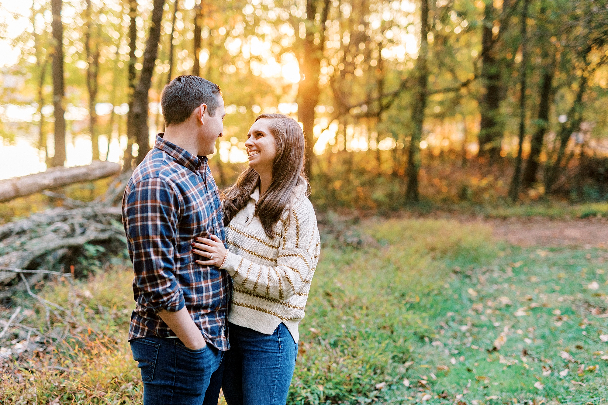 bride and groom hug smiling together at sunset along the edge at Latta Nature Preserve