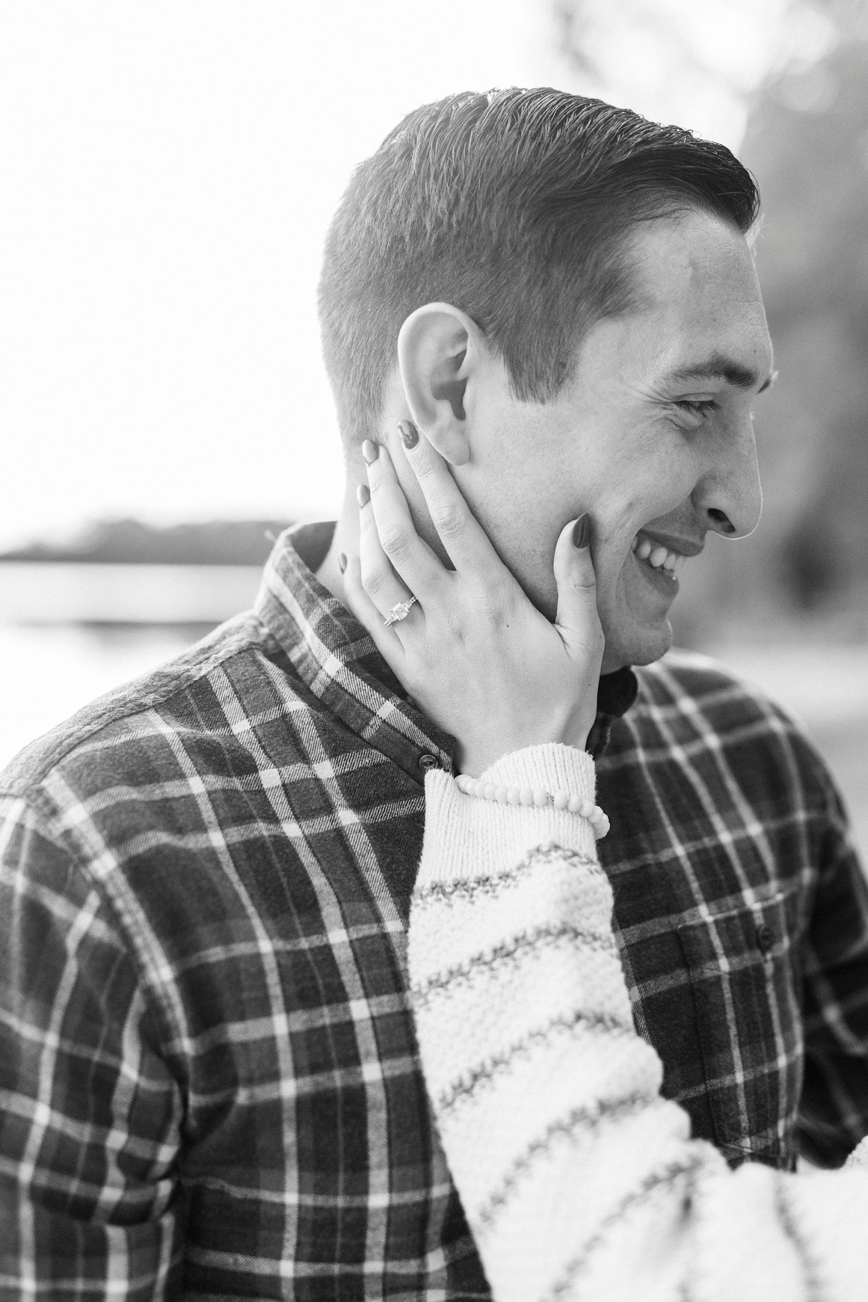 bride holds groom's cheek during fall engagement portraits at Latta Nature Preserve
