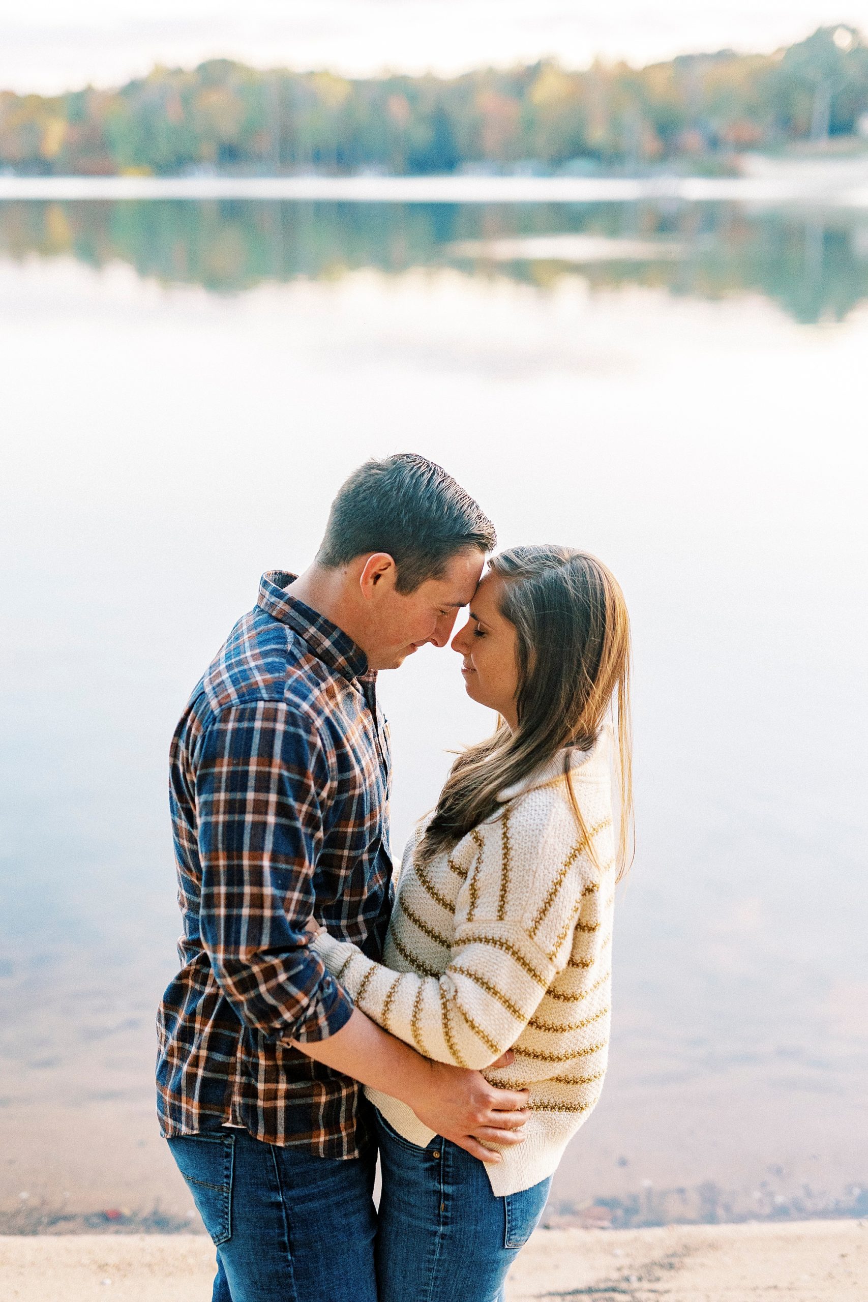 bride and groom hug by waterfront at Latta Nature Preserve