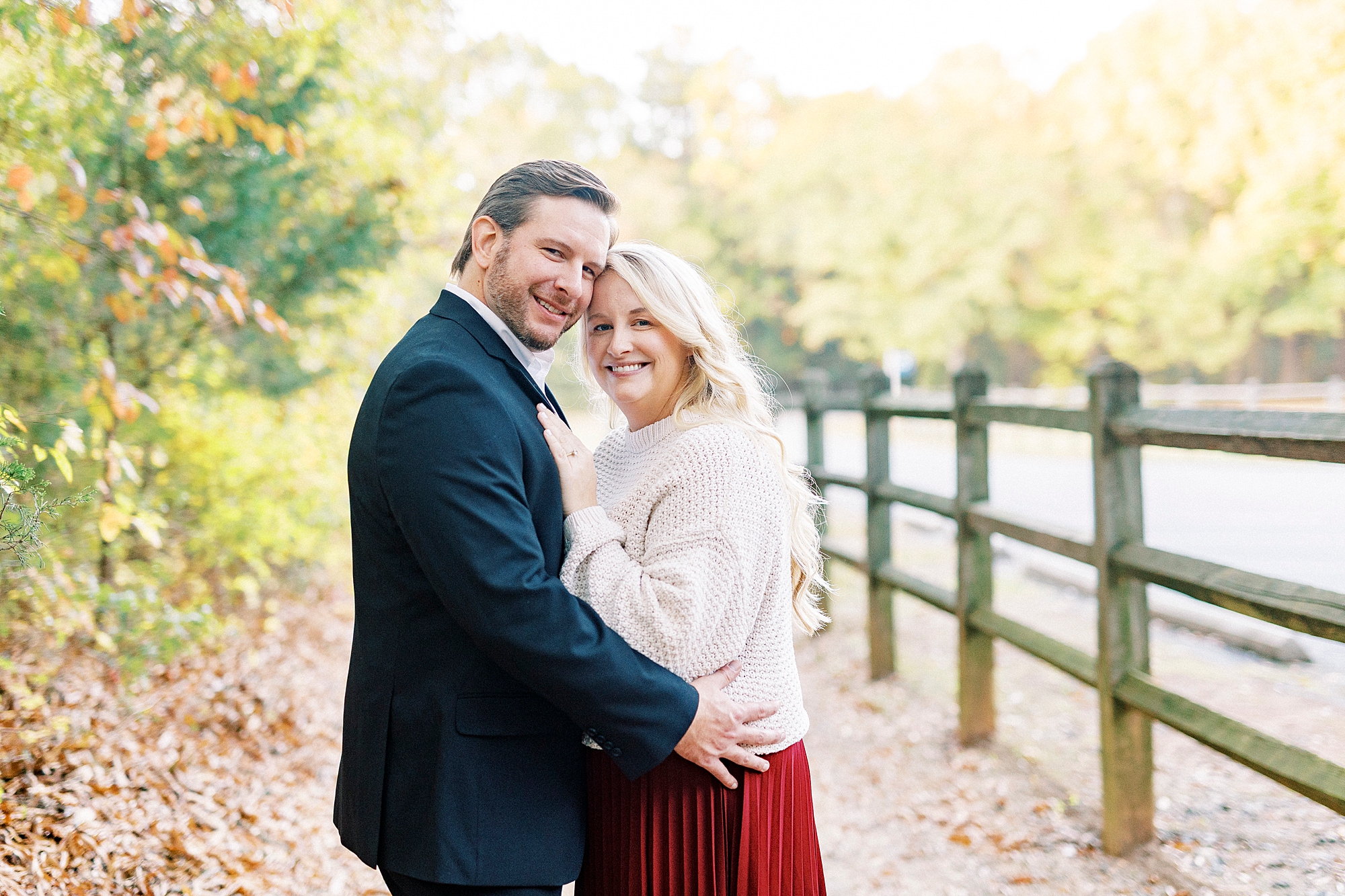 bride and groom hug by wooden fence at Latta Nature Preserve
