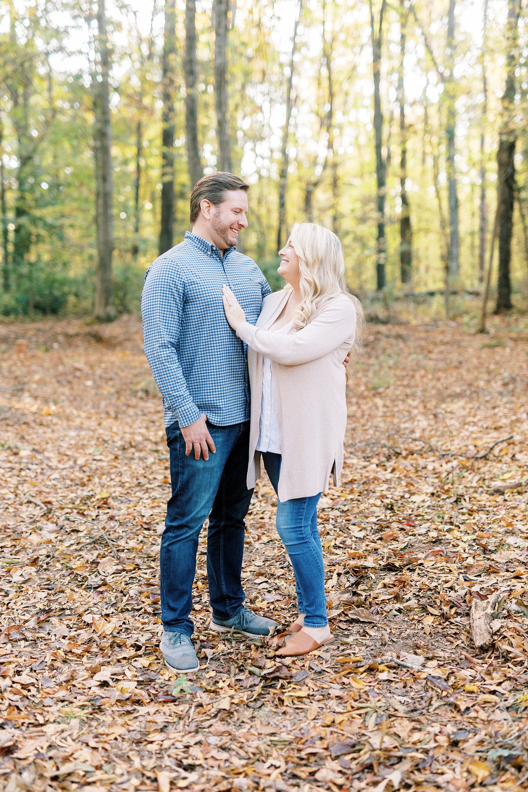 bride and groom stand together among leaves at Latta Nature Preserve