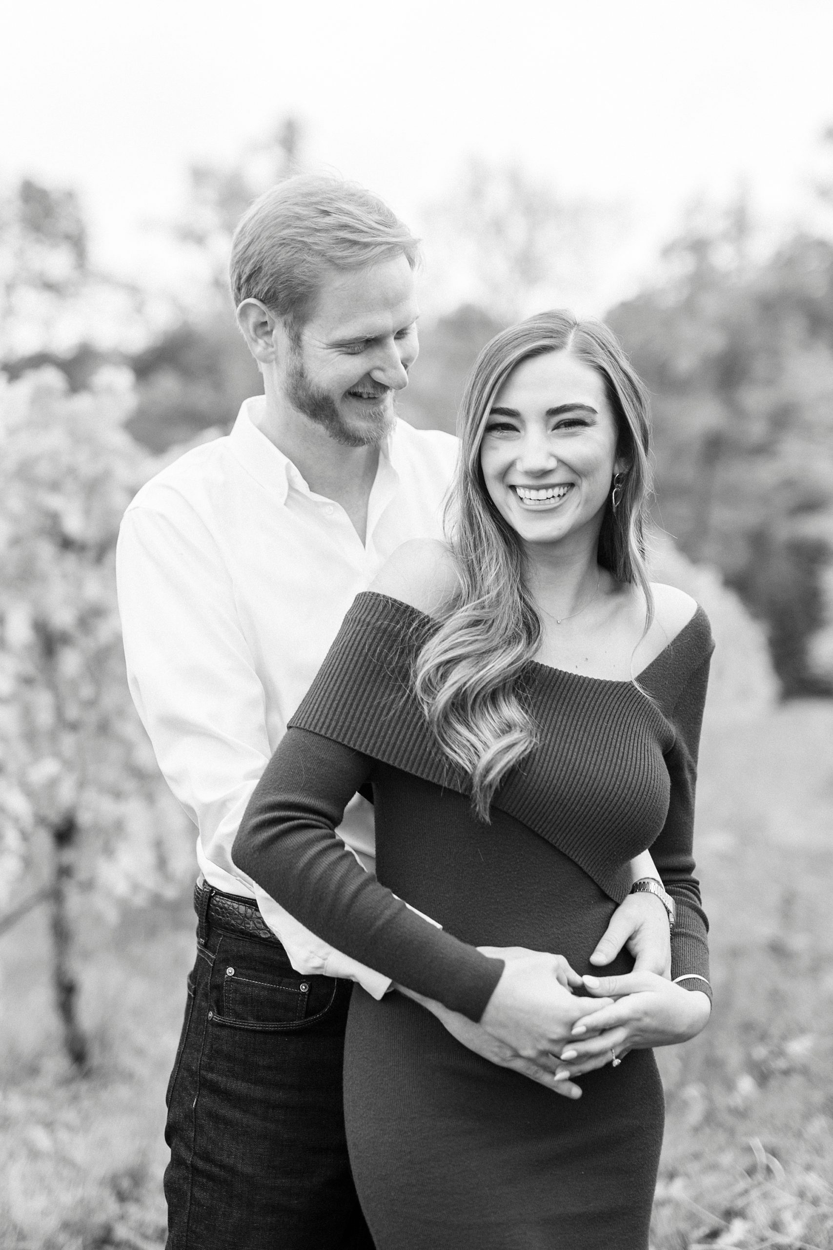 man makes fiancee laugh during Raffaldini Vineyards engagement portraits 