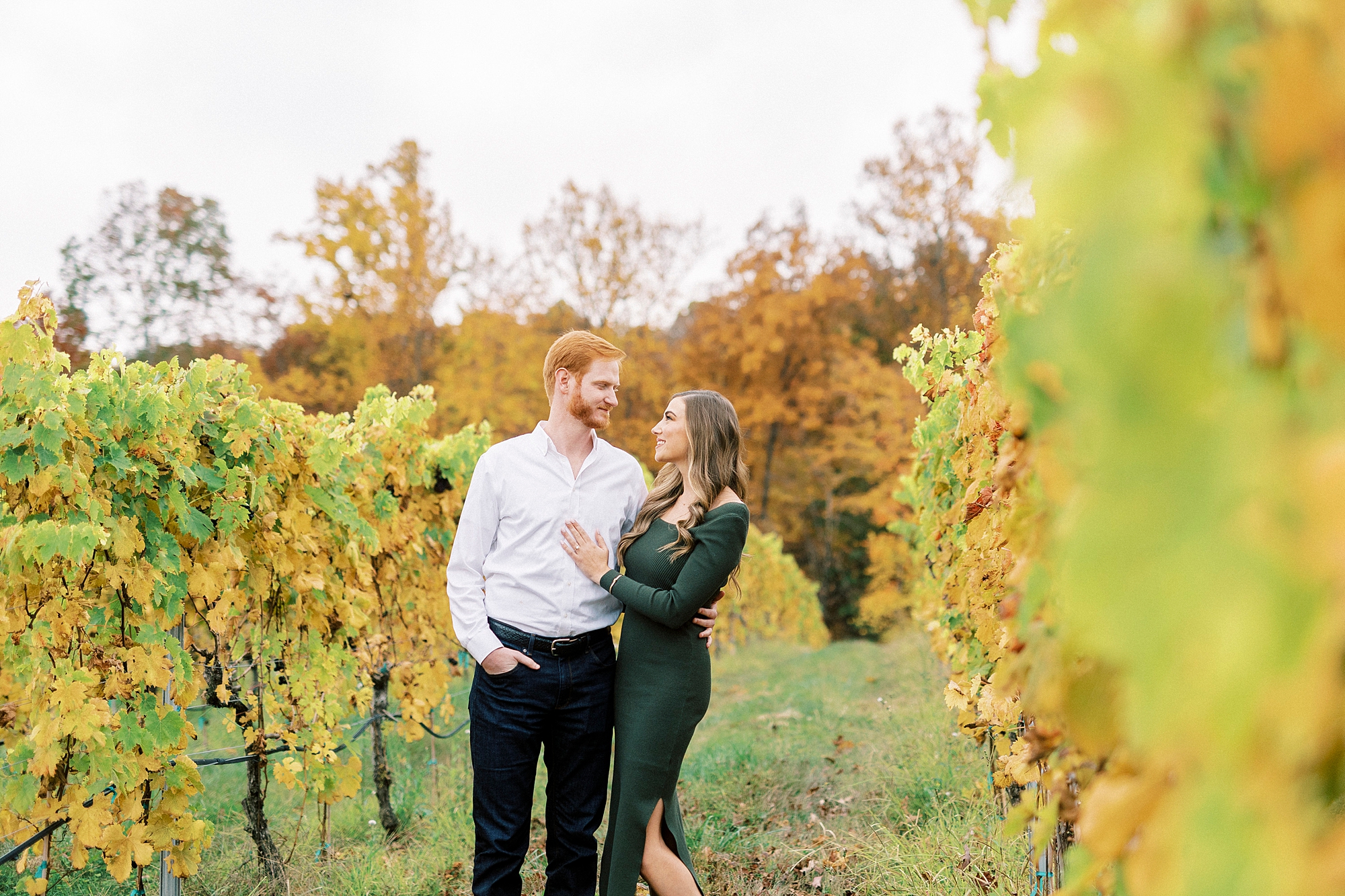 bride in chic green dress hugs groom between vines at Raffaldini Vineyards